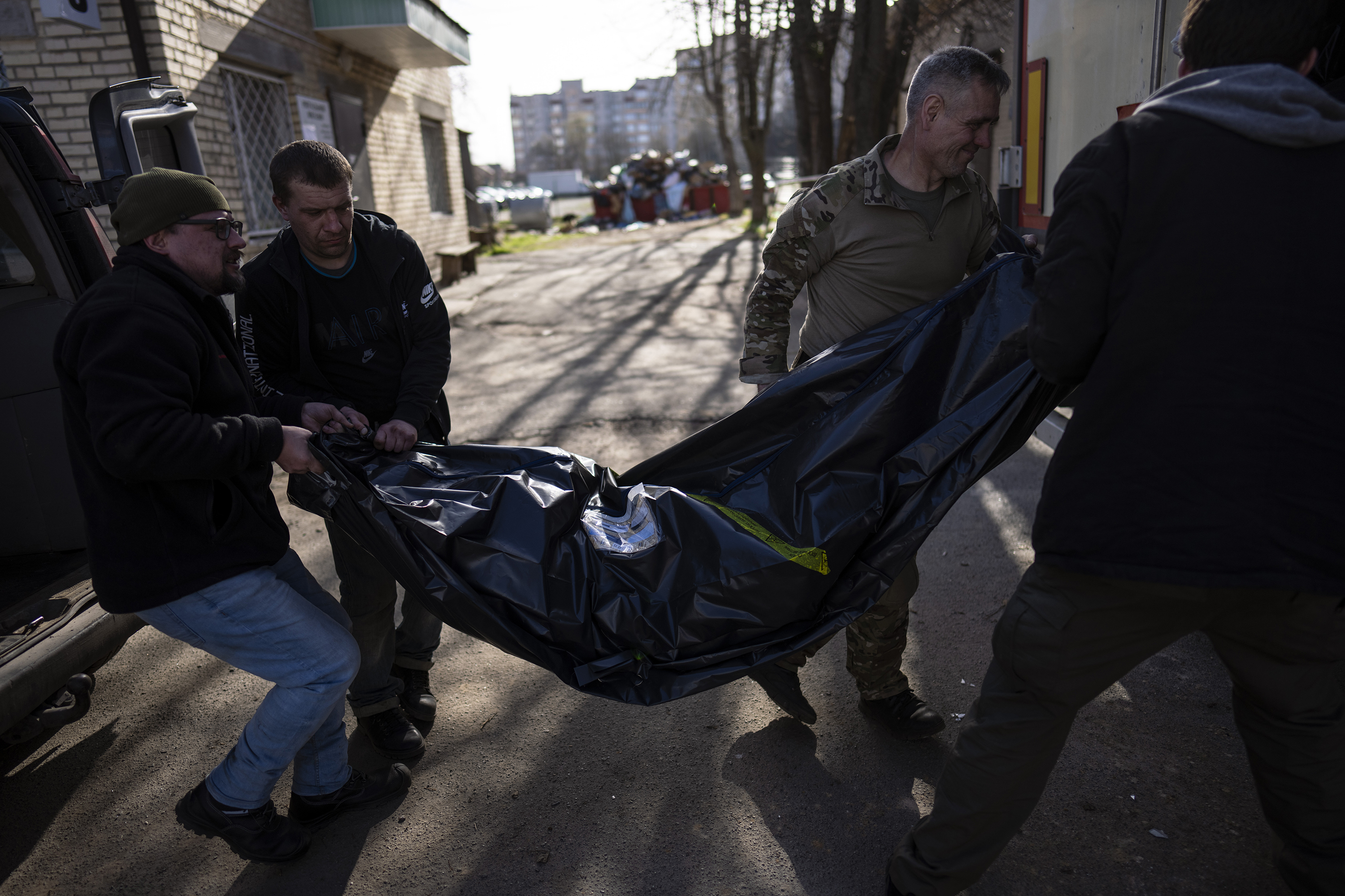 April 14: Volunteers carry the body of a man killed during the war to a refrigerated container in Bucha, in the outskirts of Kyiv, Ukraine.