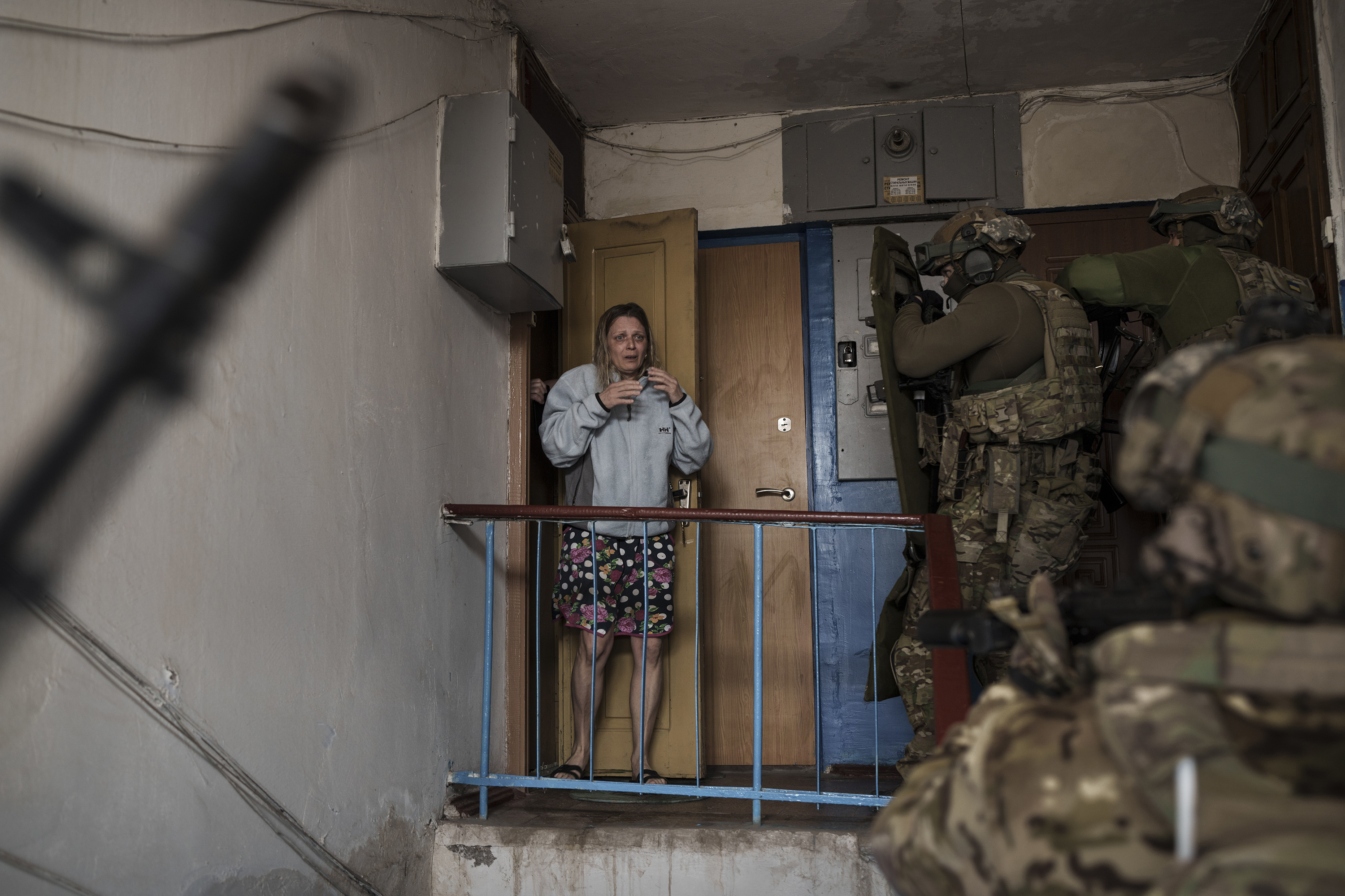 April 14: A woman looks as Security Service of Ukraine (SBU) servicemen enter a building during an operation to arrest suspected Russian collaborators in Kharkiv, Ukraine.