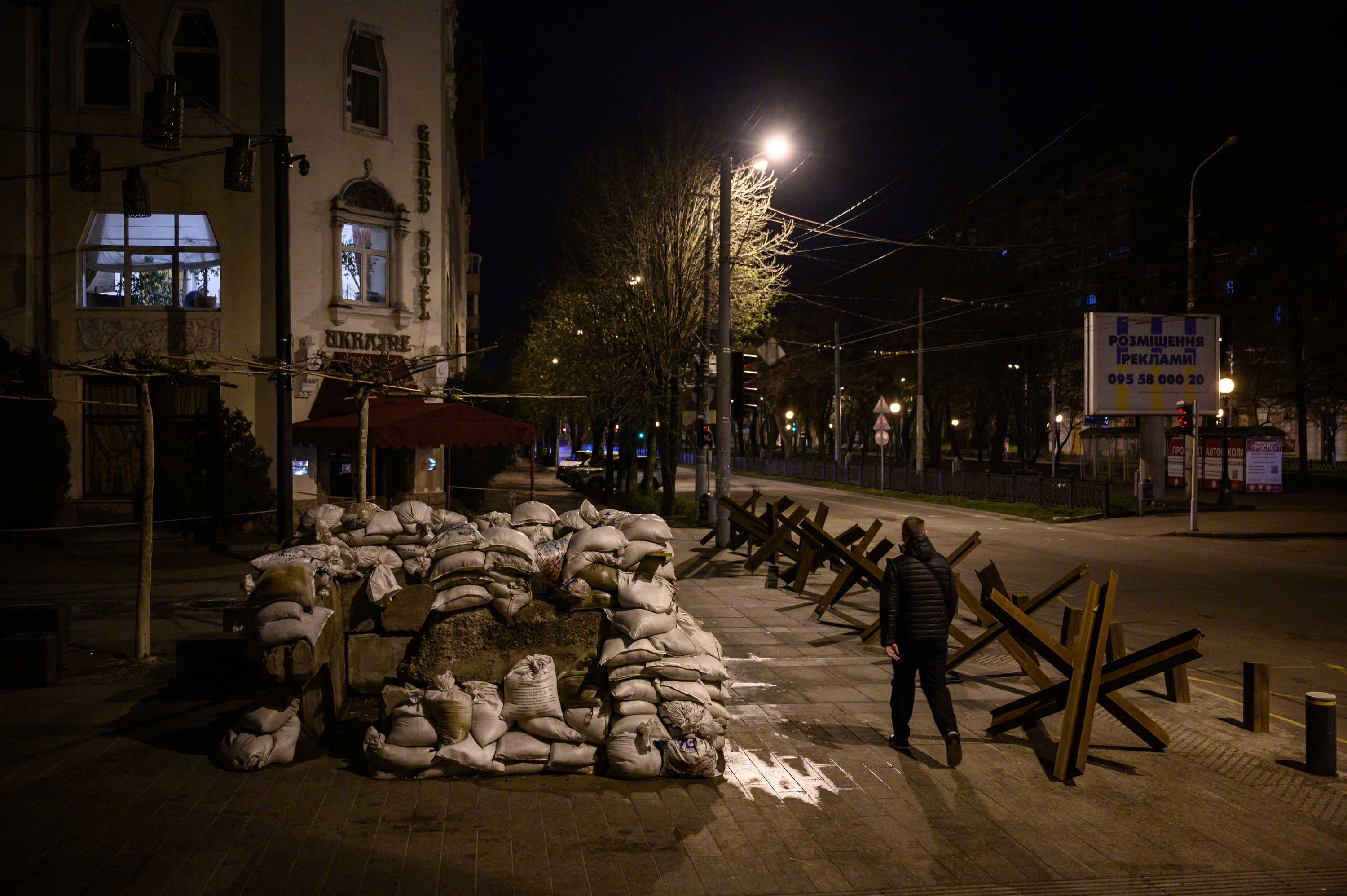 April 14: A pedestrian walks along a street past anti-tank obstacles shortly before a curfew in Dnipro, amid Russia's military invasion launched on Ukraine.