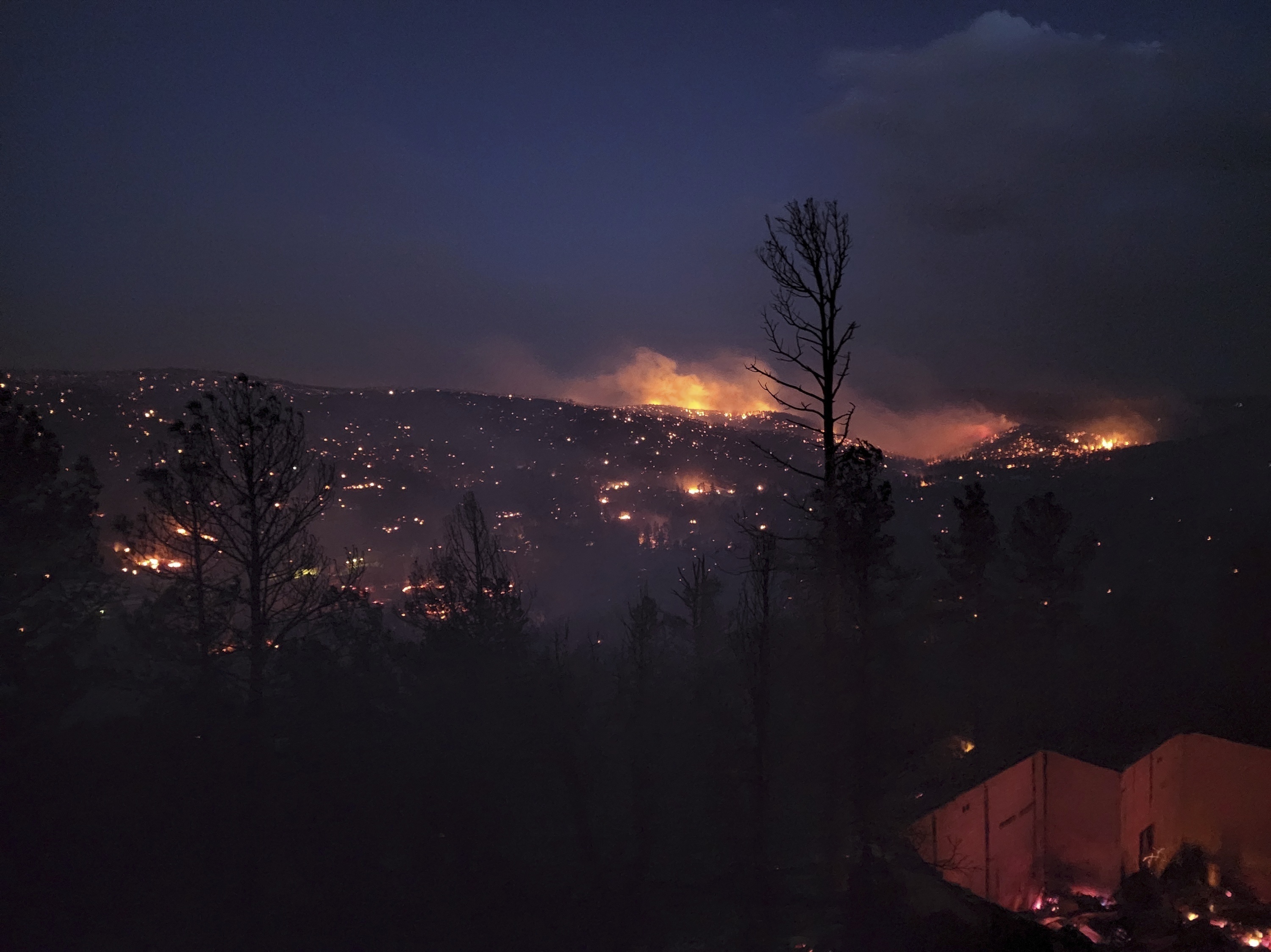 Flames burn along a hillside in Ruidoso, N.M., on Wednesday. Officials say a wildfire has burned about 150 structures, including homes, in the town. (Alexander Meditz via AP)