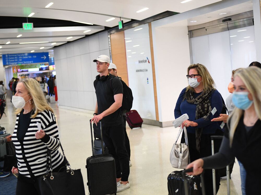 Airline passengers, some not wearing face masks following the end of public transportation masking rules, wait to board a SkyWest Airlines flight at Los Angeles International Airport on Tuesday. (AFP via Getty Images)