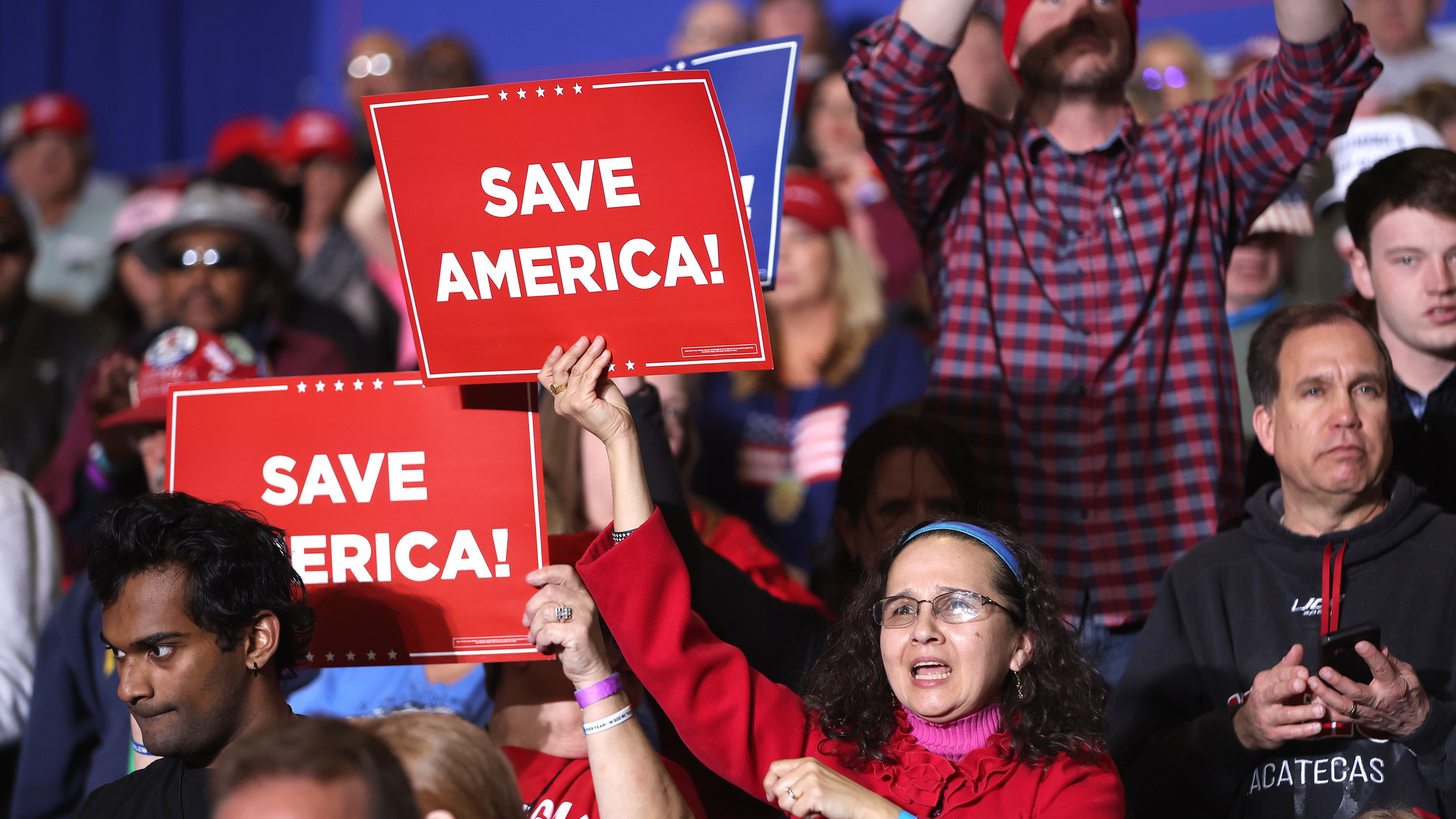 Rallygoers hold signs at an event hosted by former President Donald Trump in Michigan on April 2. (Getty Images)