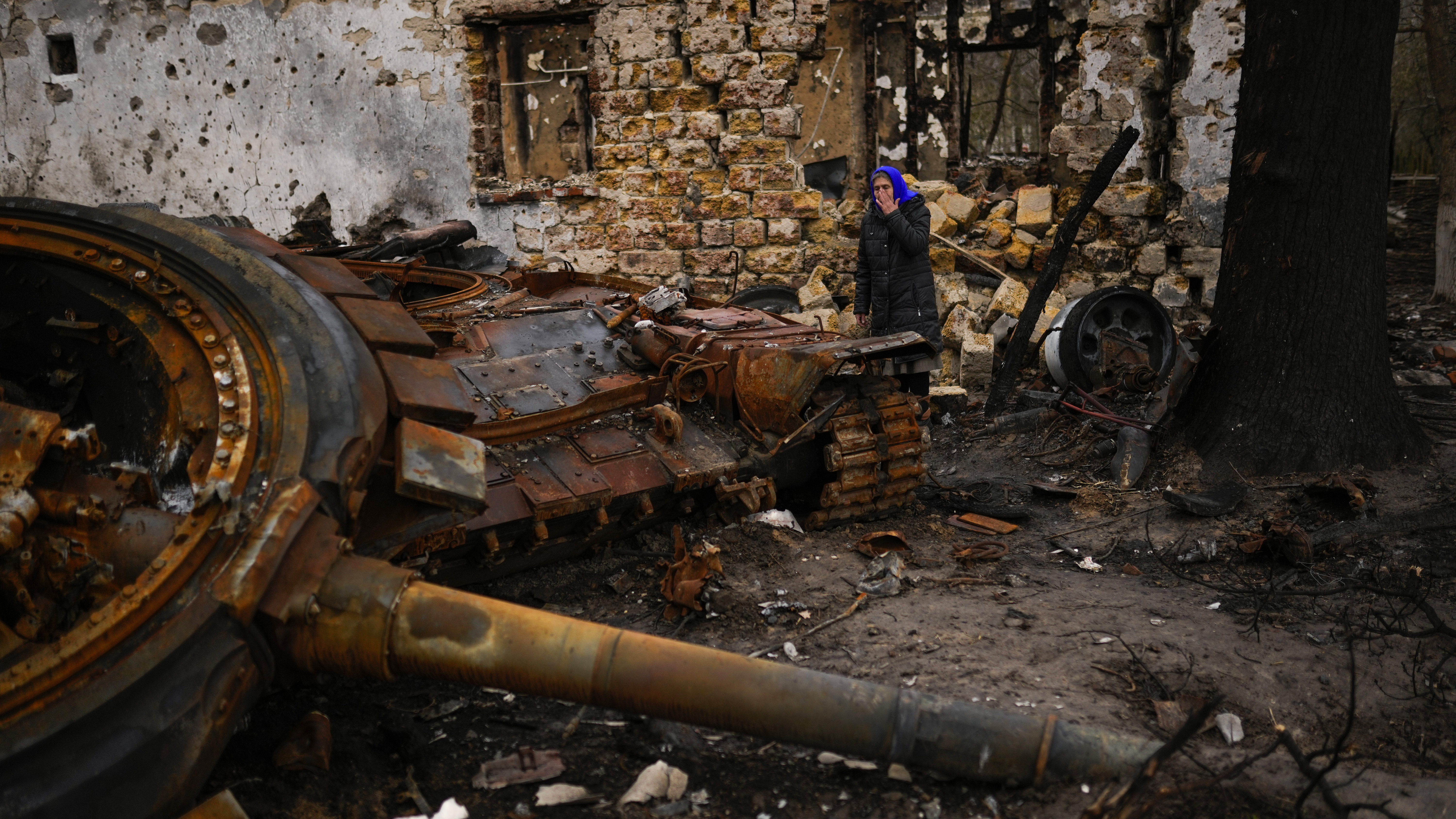 Valentyna Sherba, 68, stands next to a Russian tank in the backyard of her father