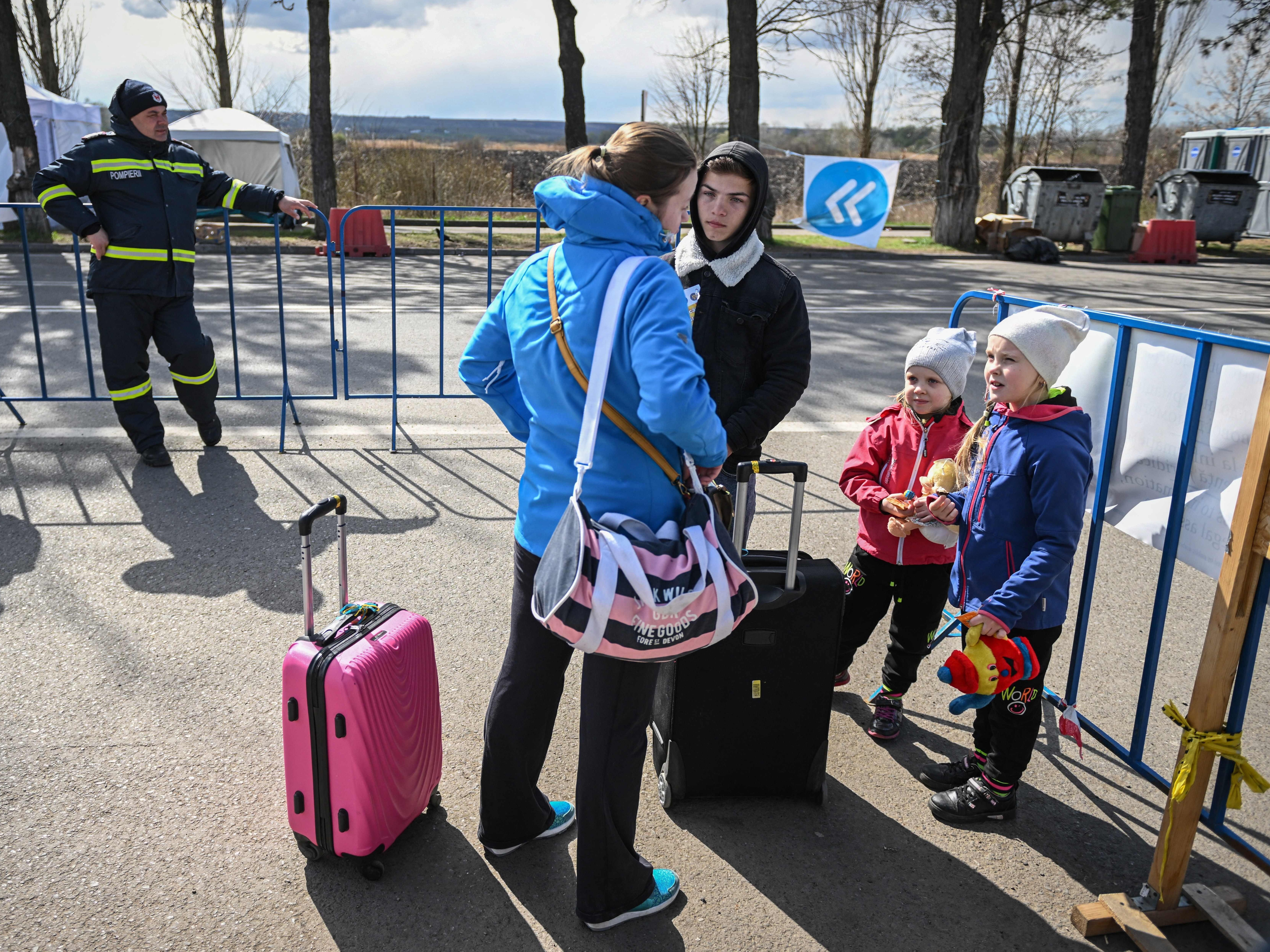 A Ukrainian refugee speaks with a local interpreter as she and her two children arrive at the Siret border crossing between Romania and Ukraine on April 18. (AFP via Getty Images)
