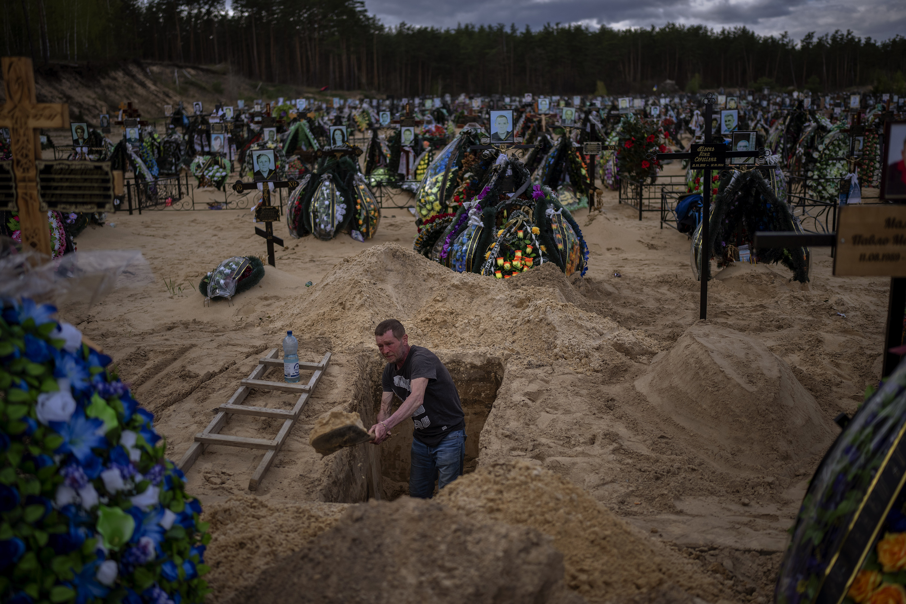 April 27: Gravedigger Alexander, digs a grave at the cemetery of Irpin, on the outskirts of Kyiv.