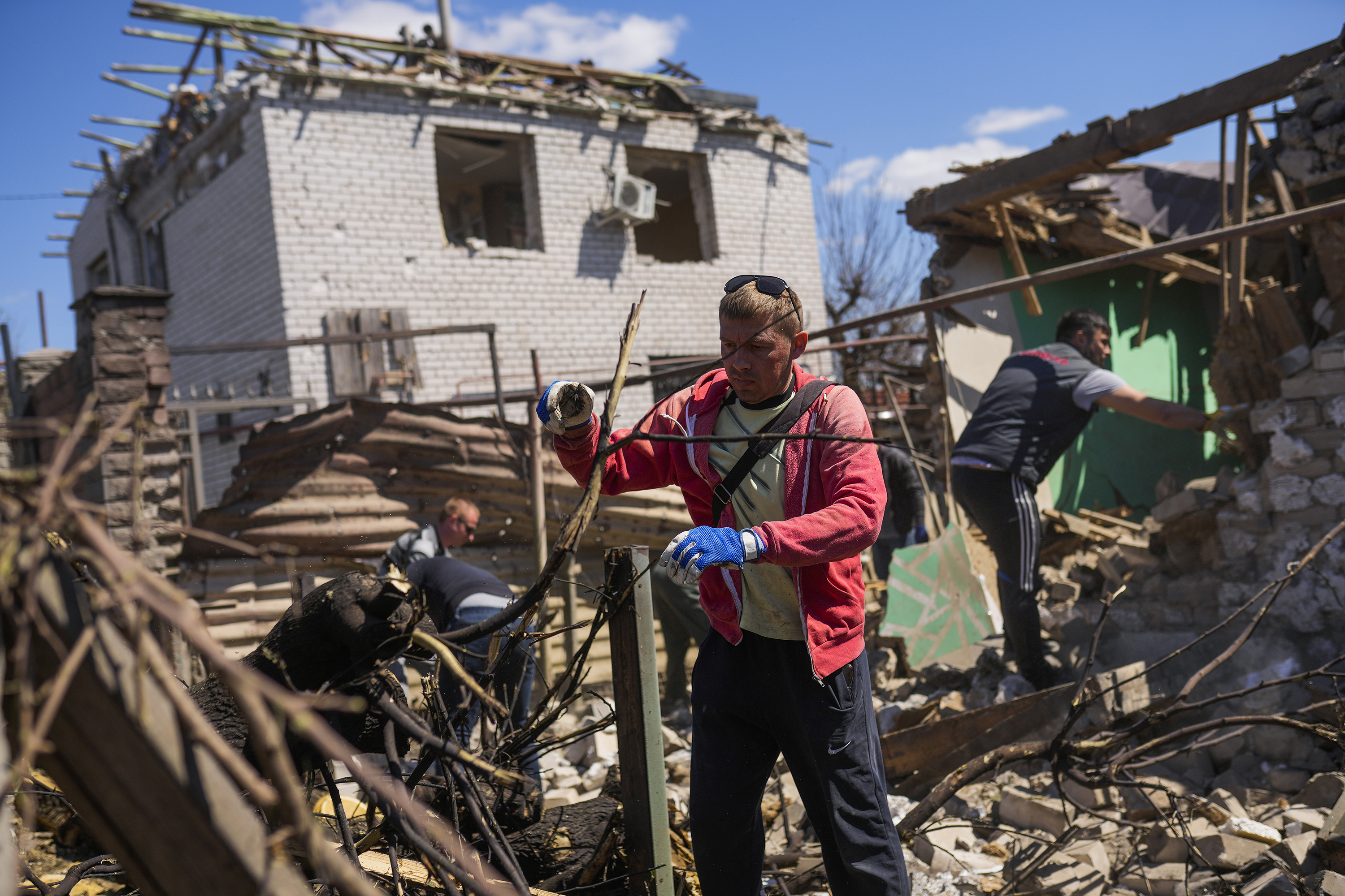 April 28: Locals remove debris from destroyed houses after a Russian rocket, hit by Ukraine's anti-aircraft system, stroke in a residencial area in Zaporizhzhia, Ukraine. The strike came as parts of southern Ukraine prepare for a further advance by Russian forces who seek to strip the country of its seacoast.