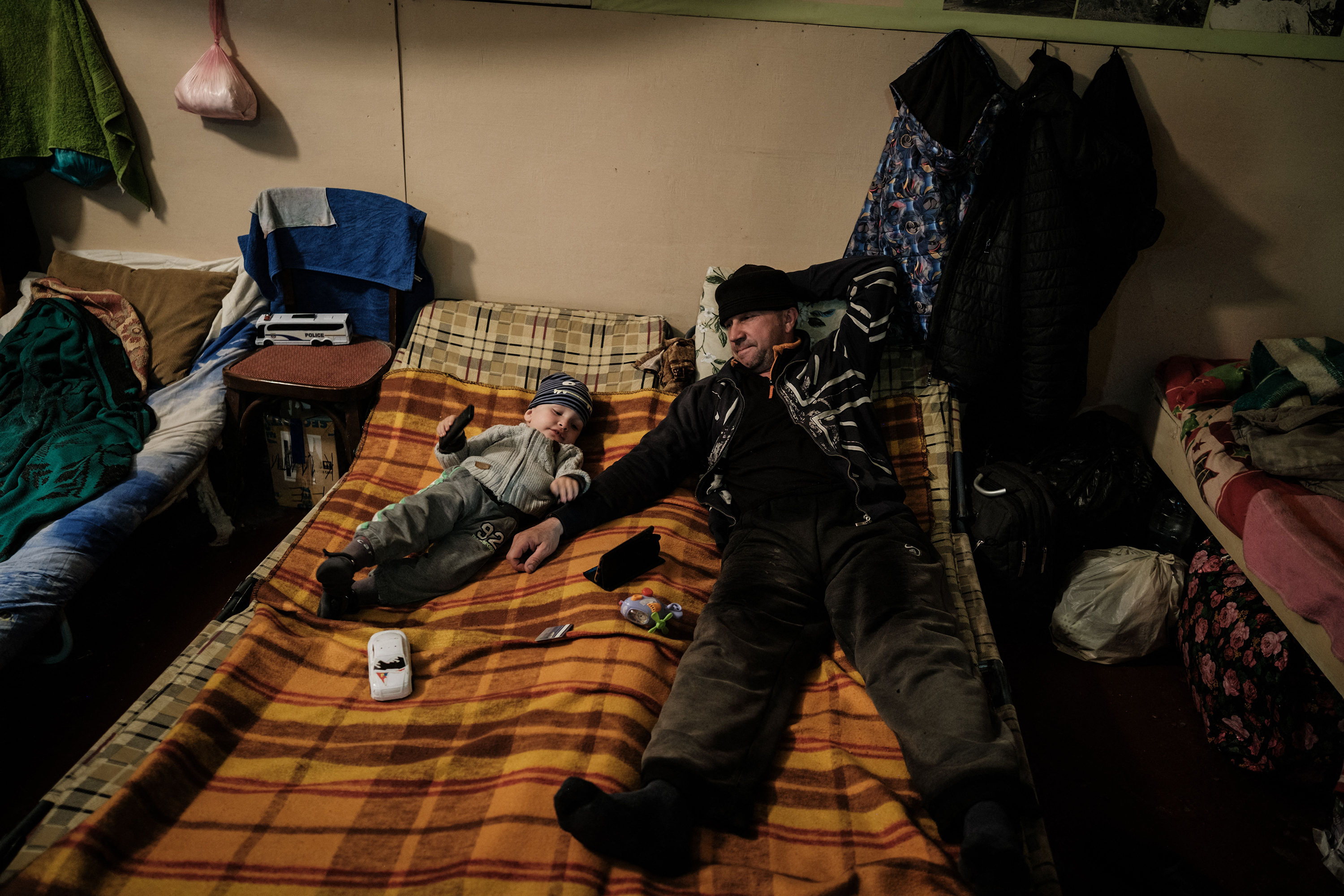 April 27: Vitalii, right, 50 year-old, stays with his son Kiril, 2 year-old, on their bed in the bunker of Ostchem factory in Severodonetsk, eastern Ukraine, amid the Russian invasion of Ukraine.