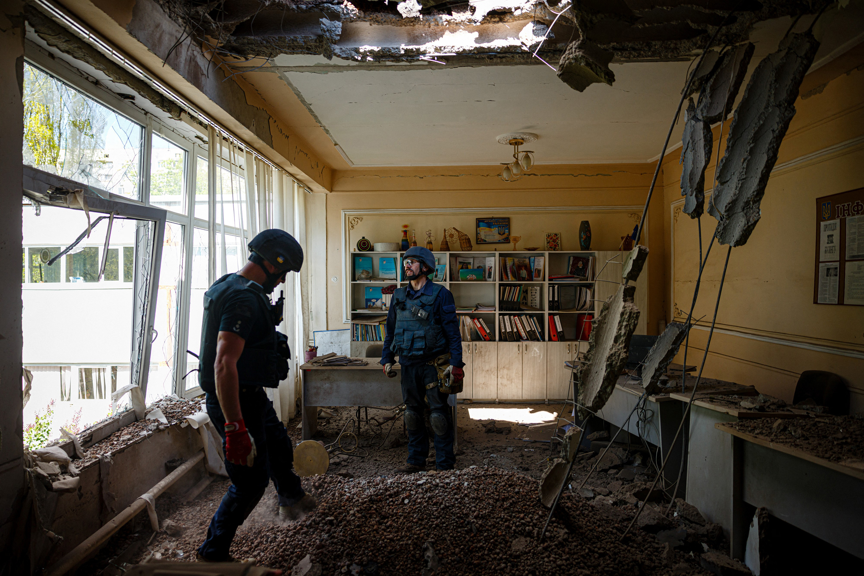 April 28: Members of a demining team of the State Emergency Service of Ukraine check for unexploded devices in a school building following Russian shelling in Kharkiv, eastern Ukraine, on the 64rd day of the Russian invasion of Ukraine.