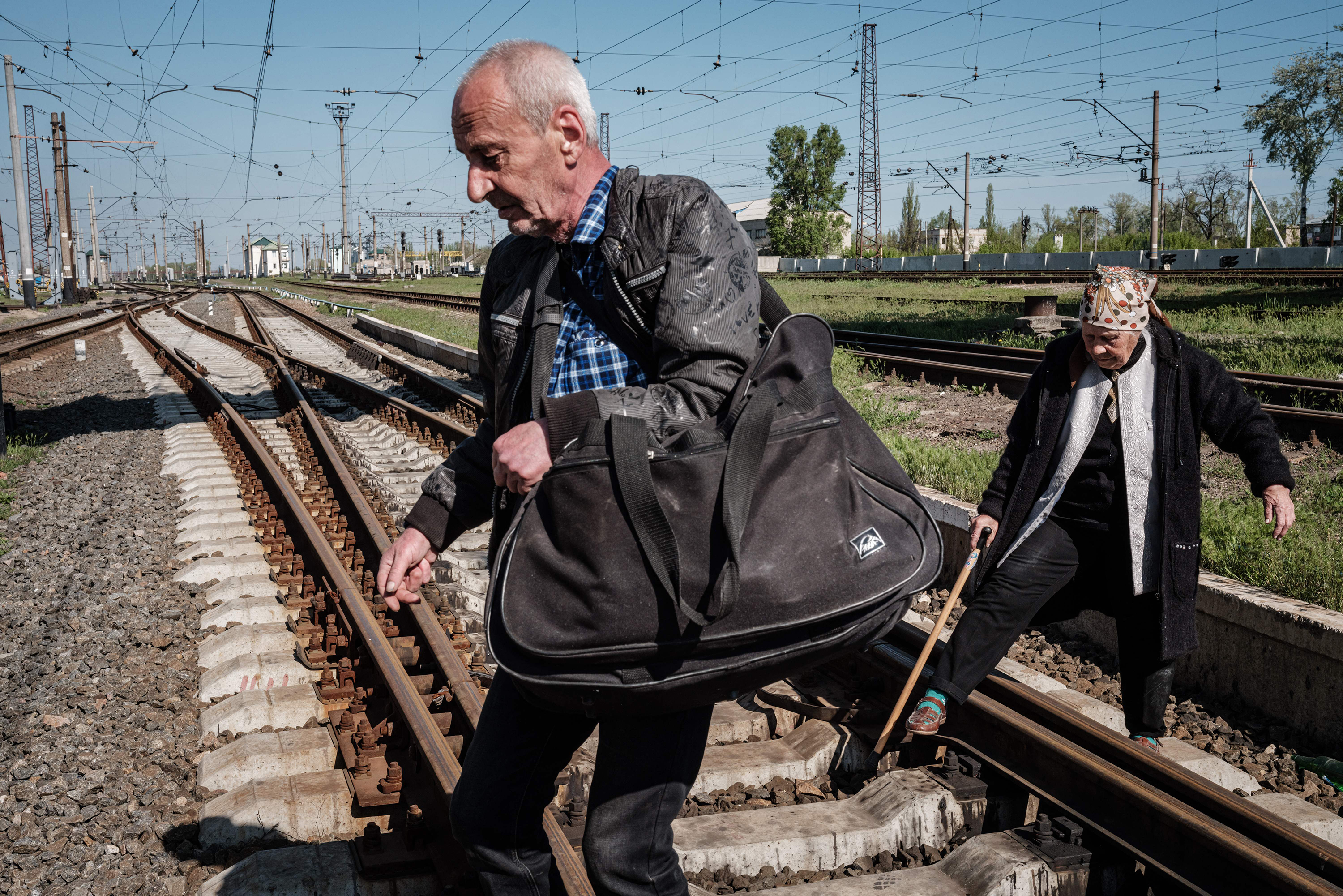 April 28: An elderly couple cross railroad tracks instead of using a flyover to get to the bus stop ahead of evacuation from Lyman, eastern Ukraine, amid the Russian invasion of Ukraine.