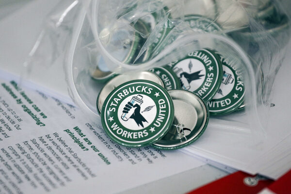 Pro-union pins sit on a table during a watch party for Starbucks' employees union election, Dec. 9, 2021, in Buffalo, N.Y. The top lawyer for the National Labor Relations Board said Thursday, April 7, she will ask the board to rule that mandatory meetings some companies hold to persuade their workers reject unions is in violation of federal labor law.