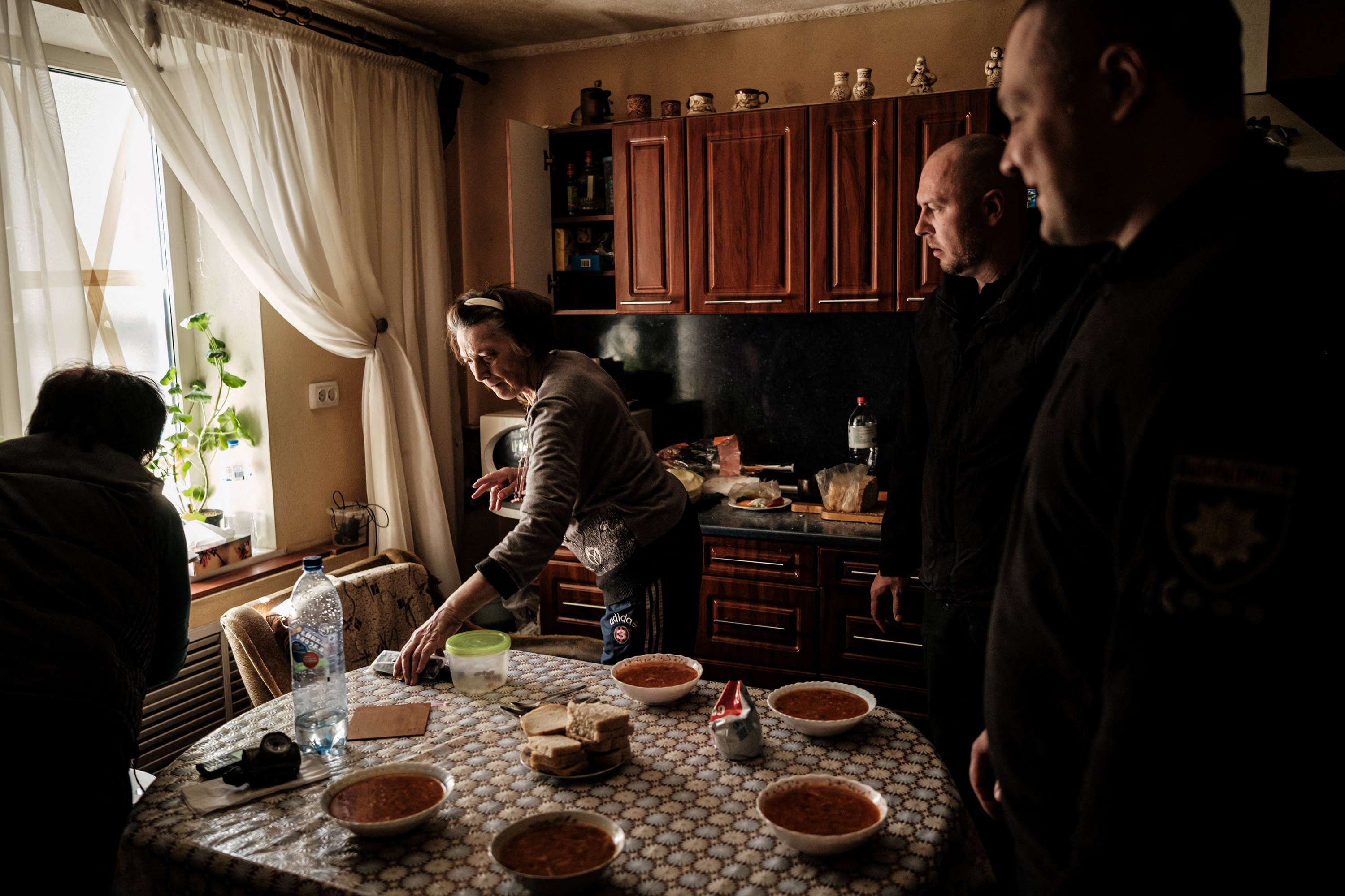 April 28: Igor Ugnevenko,, second from the right, the head of Lyman city police, and his colleague are served Ukraine's traditional soup Borscht at the house where they deliver some necessary items for a pregnant woman in Lyman, eastern Ukraine, amid Russian invasion of Ukraine.