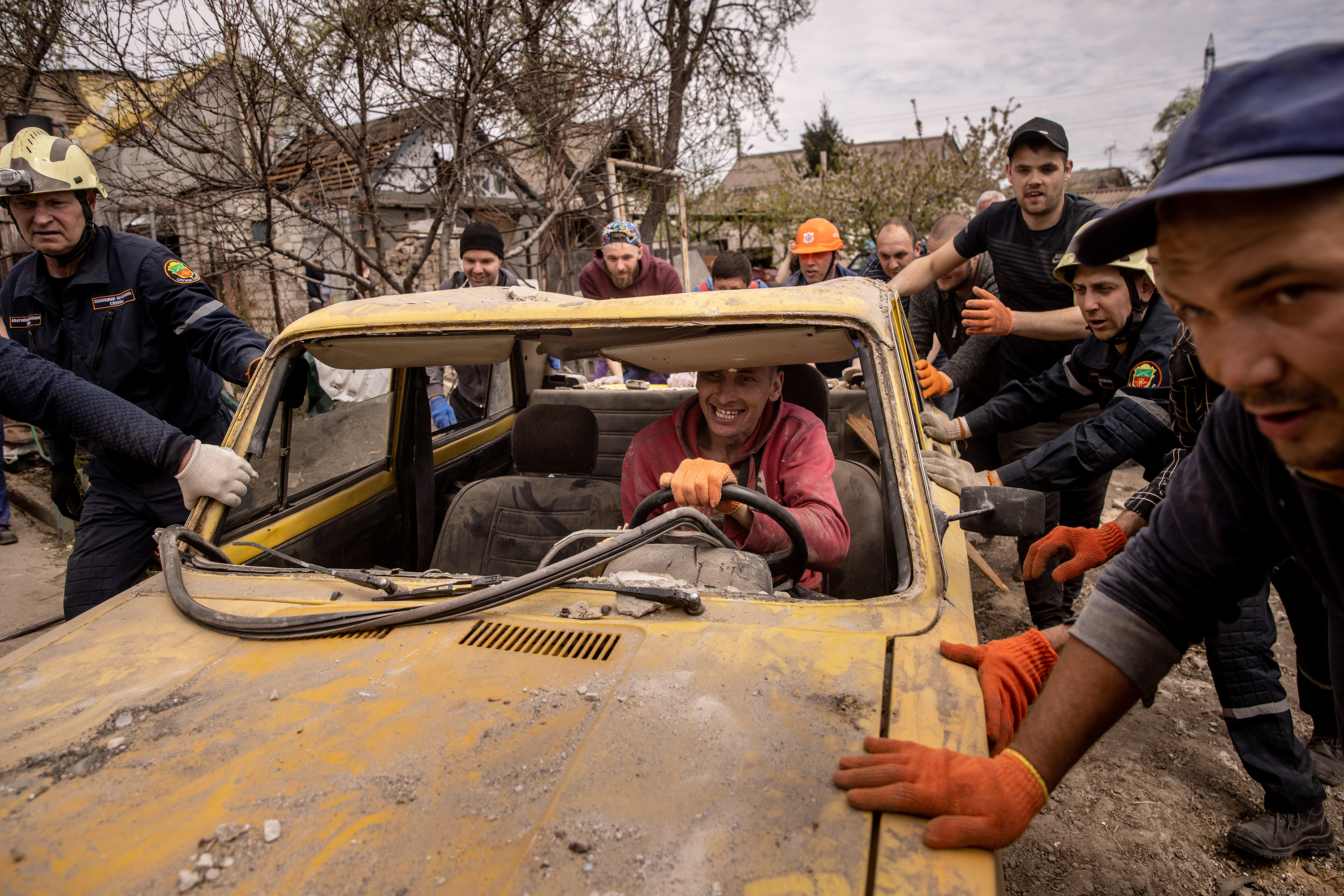 April 29: Residents and emergency services personnel push a damaged car from the driveway of a destroyed house during clean up operations a day after a Russian attack in Zaporizhia, Ukraine. Russia has stepped up its attacks in southeast Ukraine as it tries to advance further into Donetsk and Zaporizhzhia Oblasts.