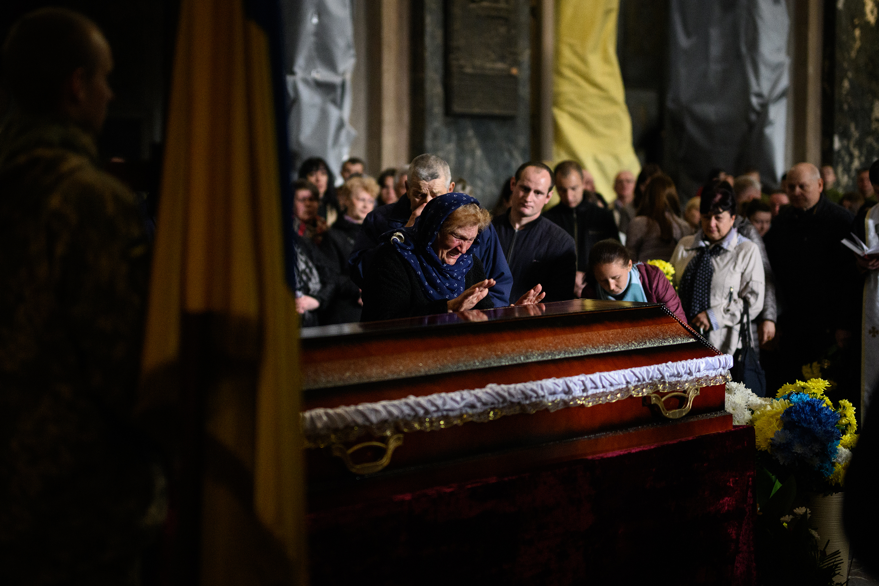 April 29: Mourners grieve during the funeral service of fallen soldier Lubomyr Tazaev, aged 36, at the Saint's Peter and Paul Garrison Church in Lviv, Ukraine. Lviv has served as a stopover and shelter for the millions of Ukrainians fleeing the Russian invasion, either to the safety of nearby countries or the relative security of western Ukraine.