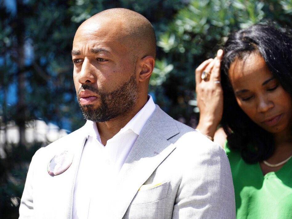 Charles Johnson wears a button with a picture of his wife, Kira, during a press conference announcing a lawsuit outside Cedars-Sinai Medical Center, Wednesday in Los Angeles. Kira Johnson died at the hospital in 2016 from complications after giving birth by cesarean section.