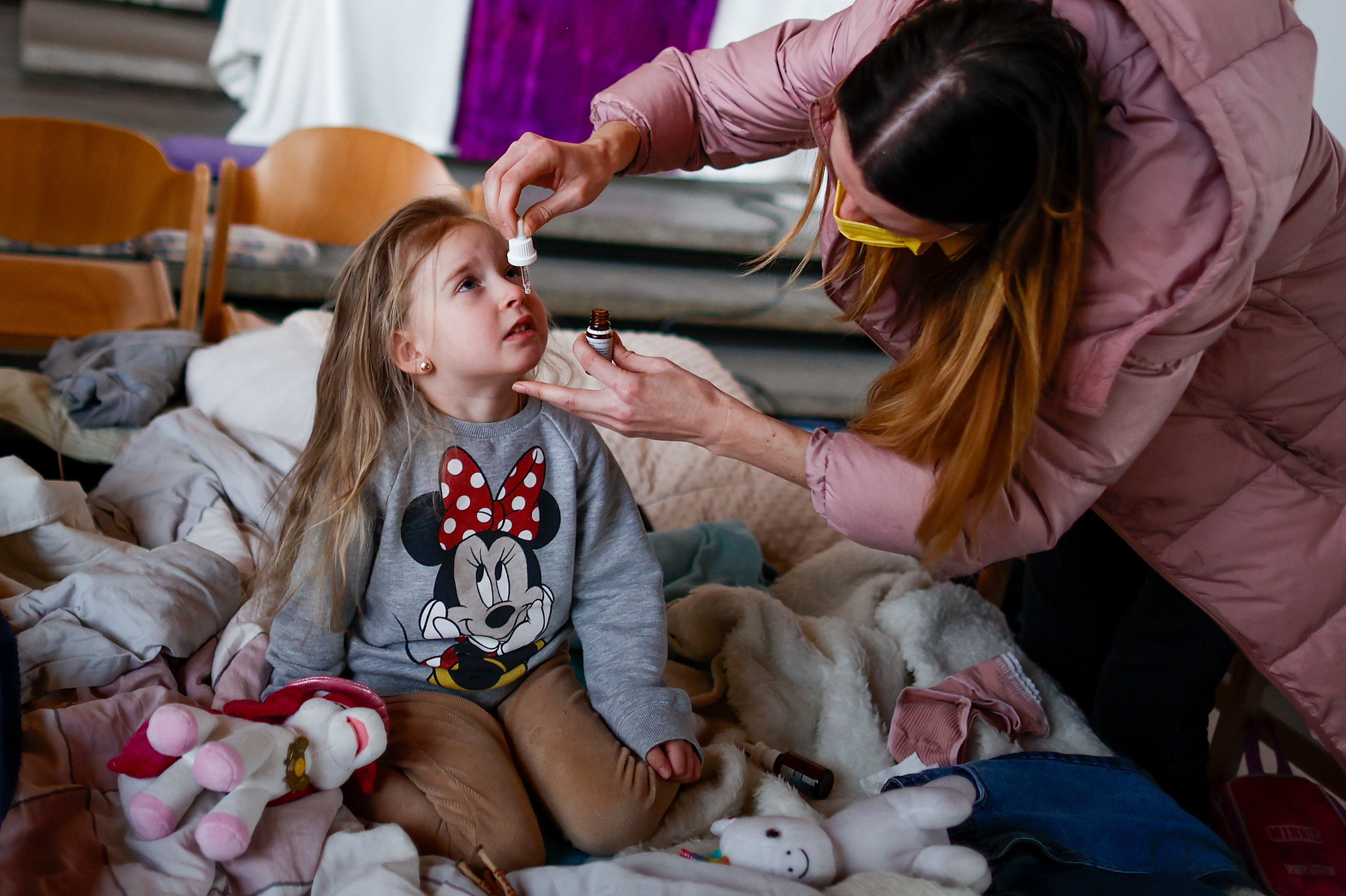 Ukrainian refugee Alina Archipova gives her daughter medication at a temporary shelter in Berlin, Germany, on March 10. (Getty Images)
