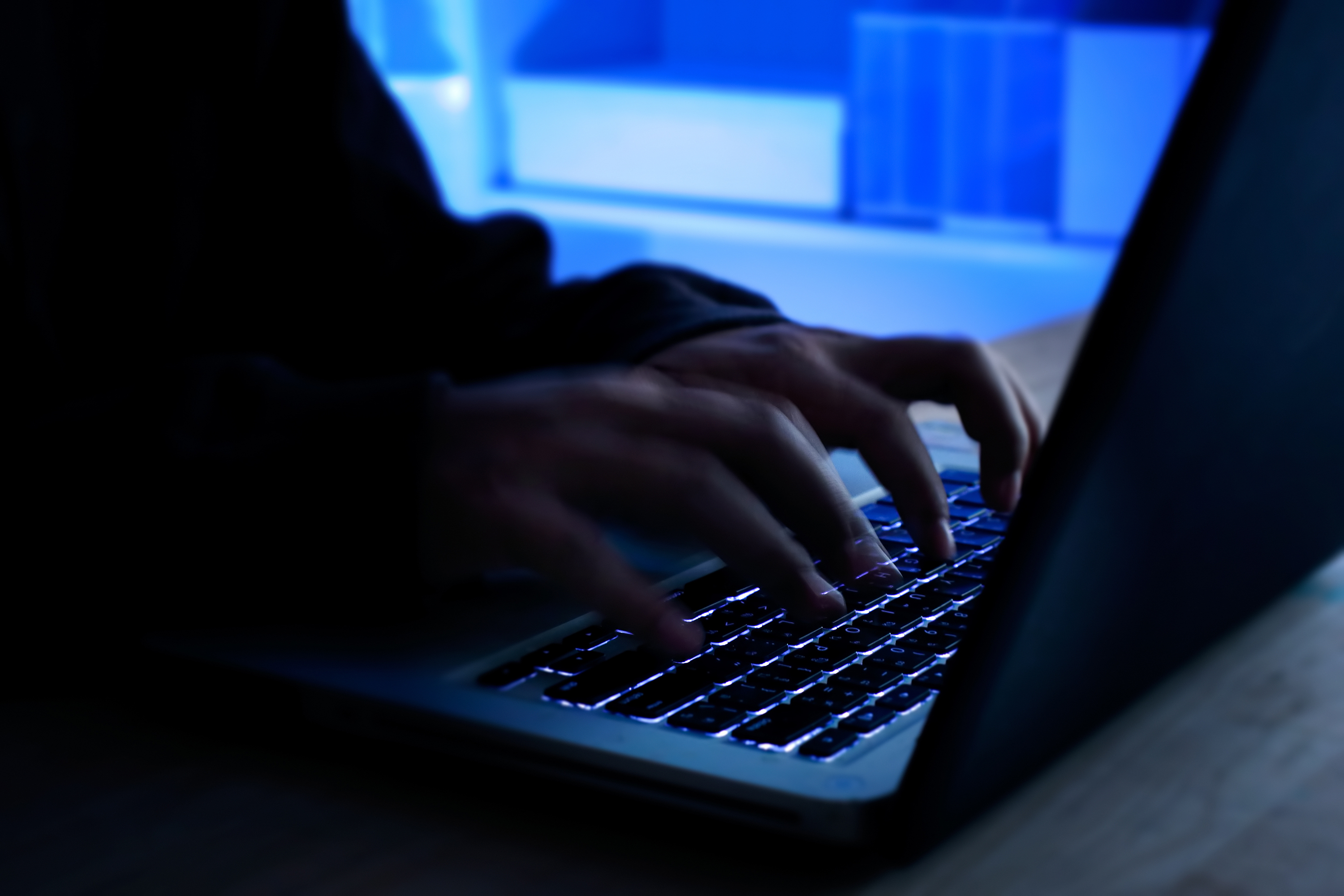 A computer programmer prints a code on a laptop keyboard. (Getty Images)