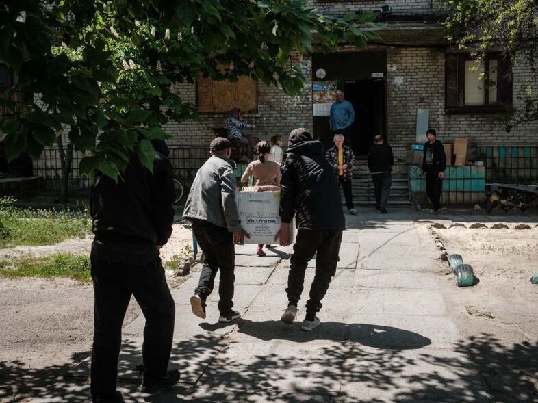Residents receive food supplies May 7 as volunteers deliver daily from a warehouse of a humanitarian aid distribution center in Severodonetsk, eastern Ukraine (Yasyoshi Chiba/AFP via Getty Images)