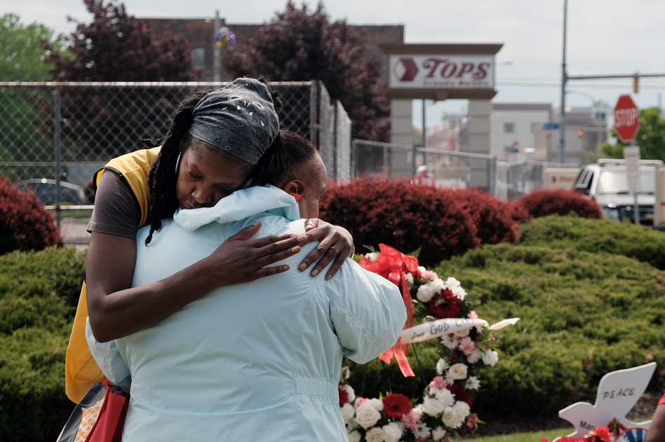 People embrace near a memorial for the shooting victims outside of Tops grocery store on May 20, 2022 in Buffalo, New York. (Spencer Platt/Getty Images)