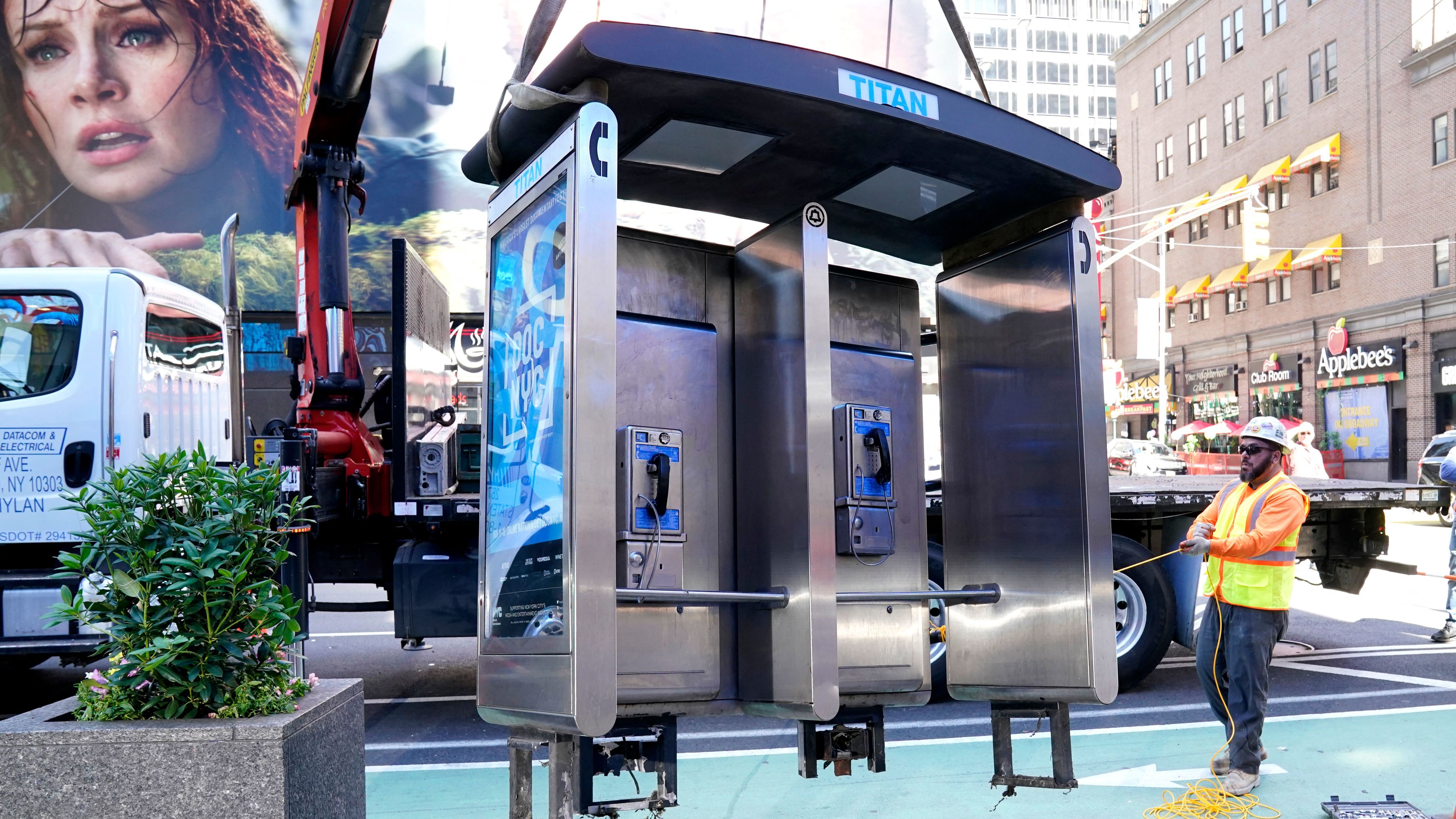 Workers remove the final New York City pay phone near Seventh Avenue and 50th Street in Midtown Manhattan on Monday. Despite the fanfare, there are still some pay phones standing in the city.