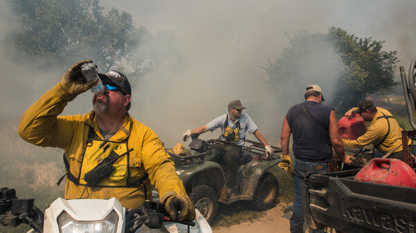 Men sit on four-wheelers handling supplies and drinking water. 