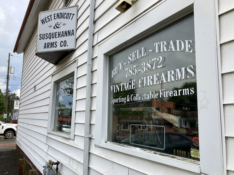 A rifle hangs on display in the window of the West Endicott & Susquehanna Arms Co., where Payton Gendron purchased firearms in Endicott, N.Y. (Michael Hill/AP)
