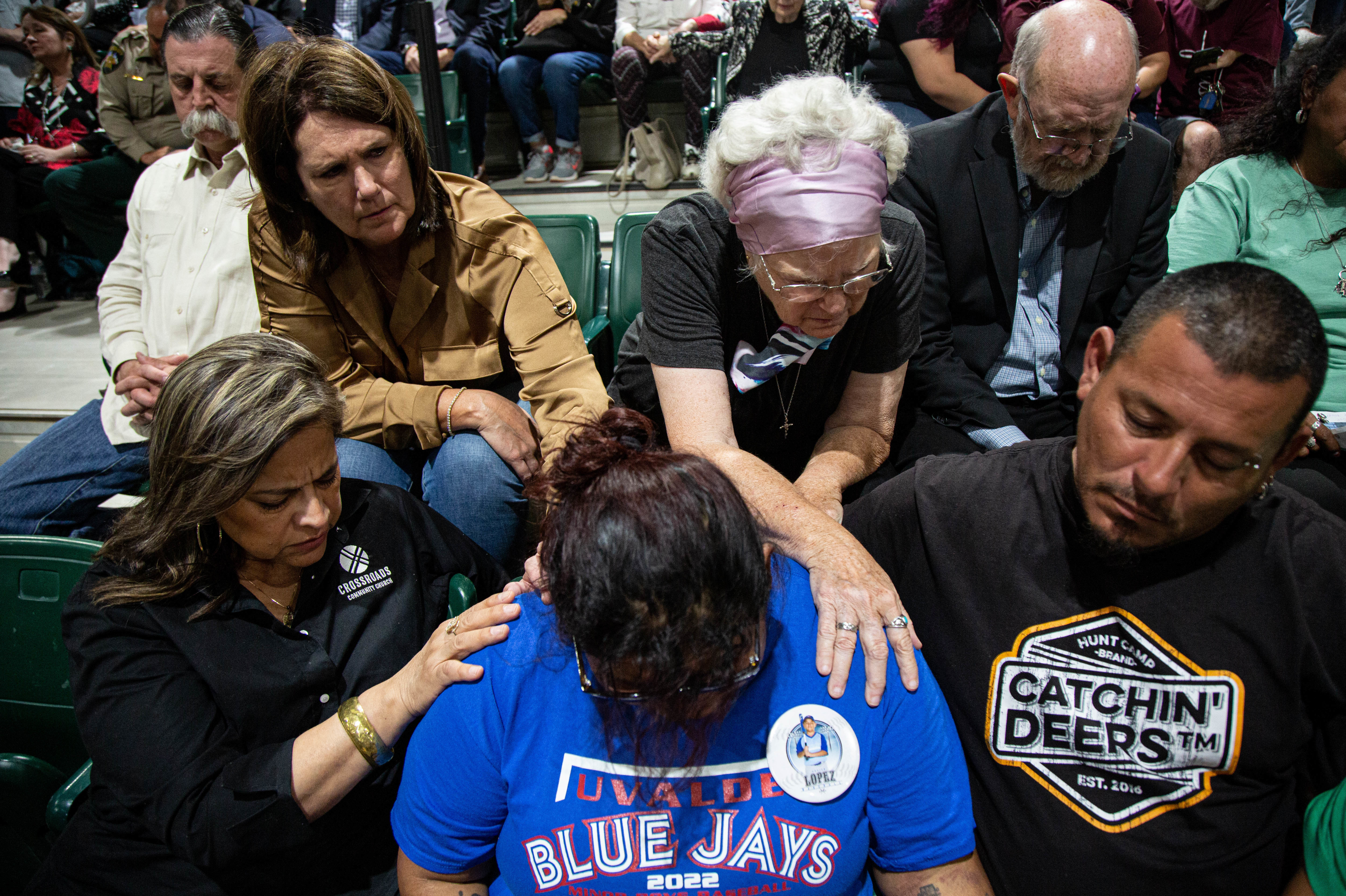 May 25: Community members pray together at a vigil for the 19 students and two adults killed in the mass shooting at Robb Elementary School on Tuesday.