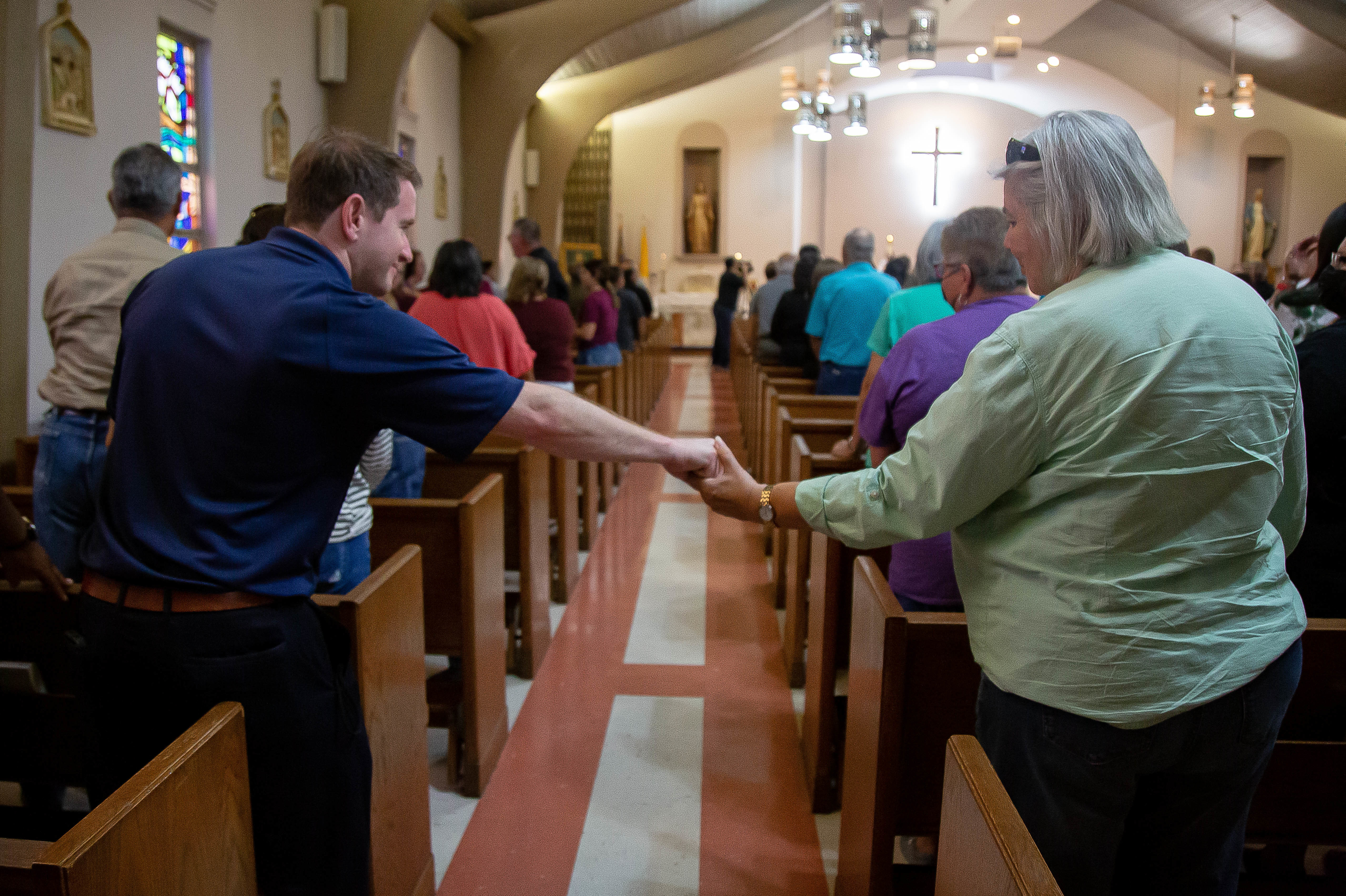 May 25: Two community members hold hands during Mass at the Sacred Heart Catholic Church in Uvalde, Texas.