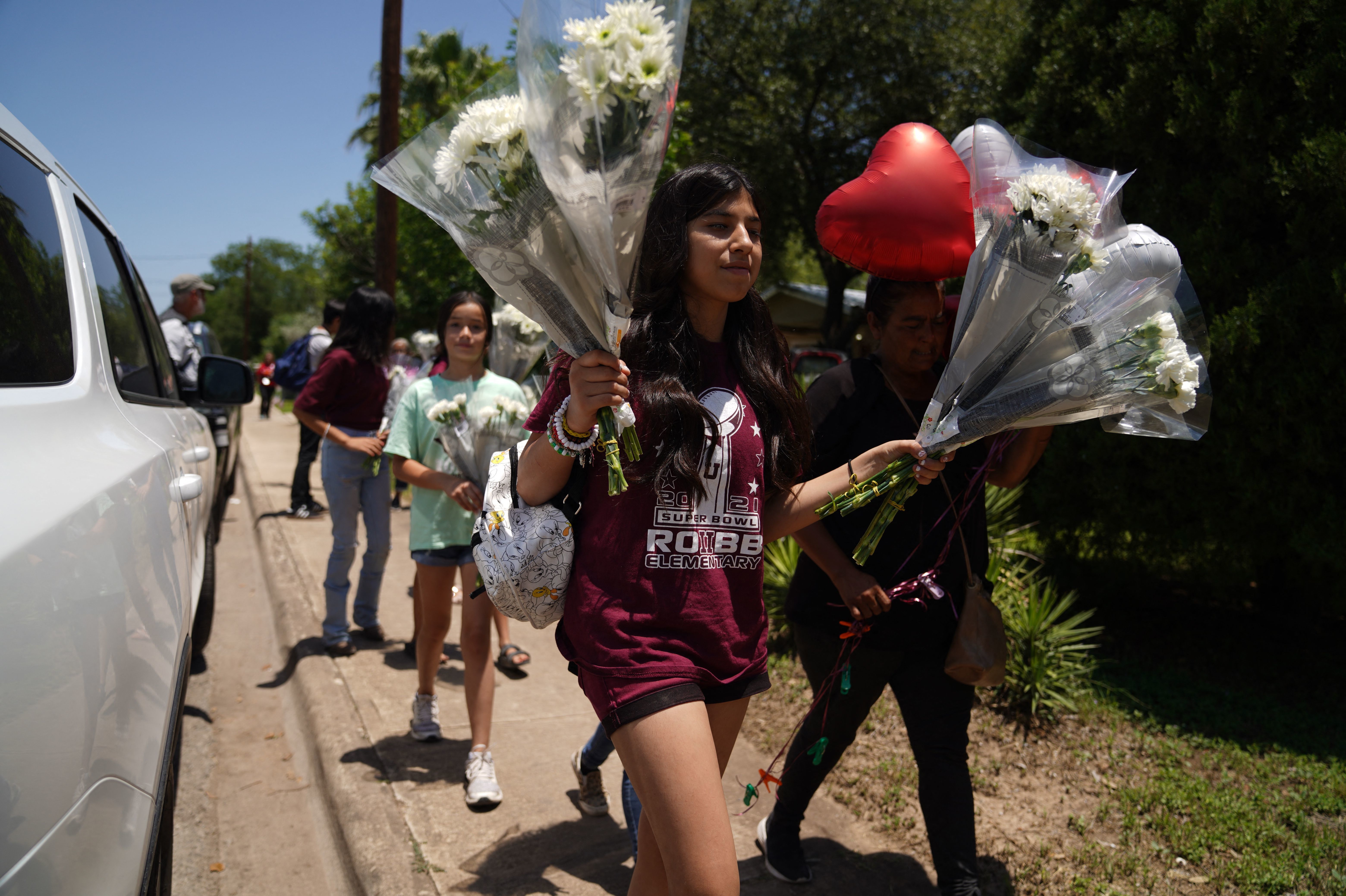 May 26: People arrive to drop off flowers at a makeshift memorial outside the Robb Elementary School.