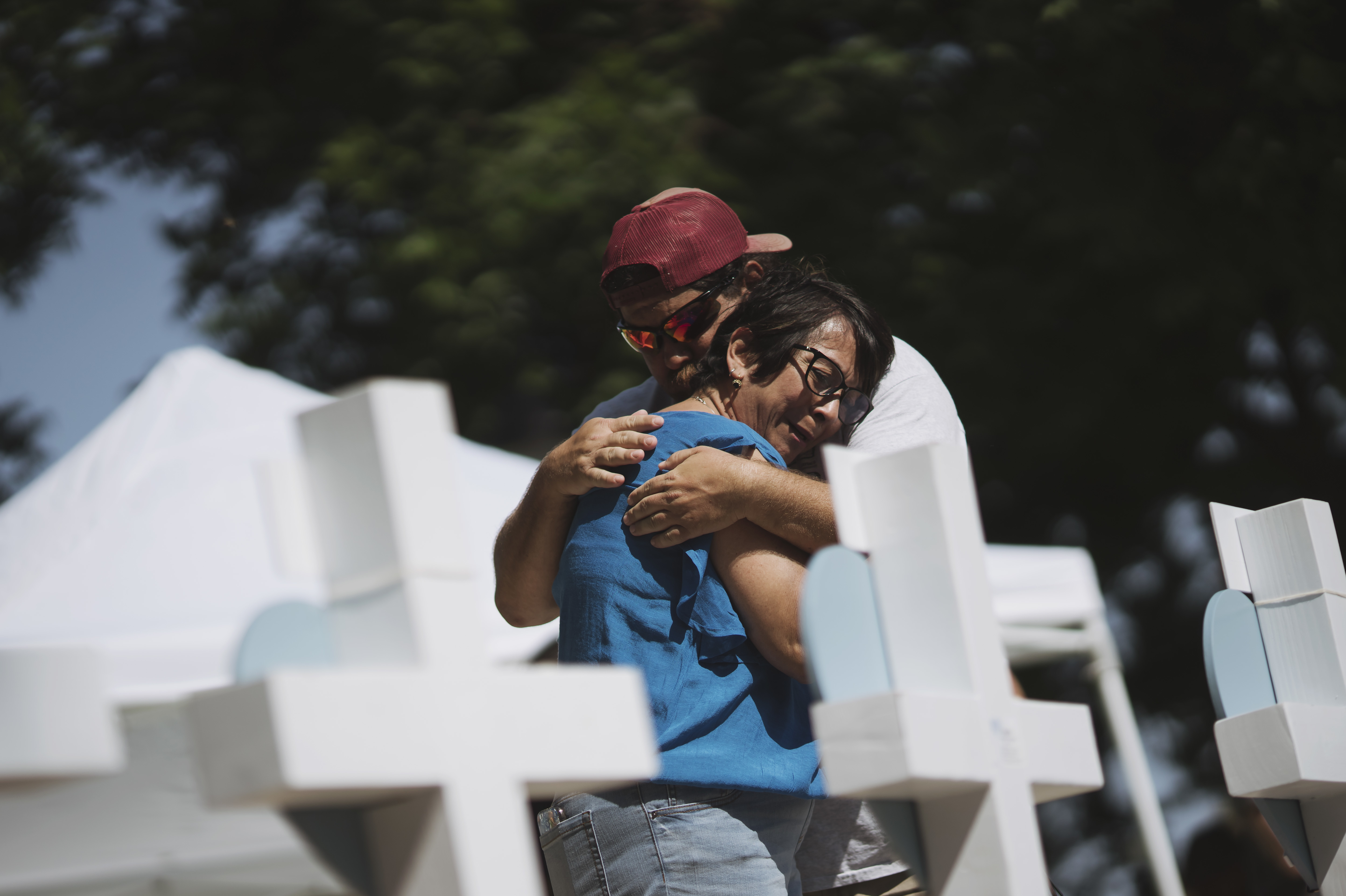 May 26: People embrace at a memorial in the town square for victims of Tuesday's mass shooting at Robb Elementary School.