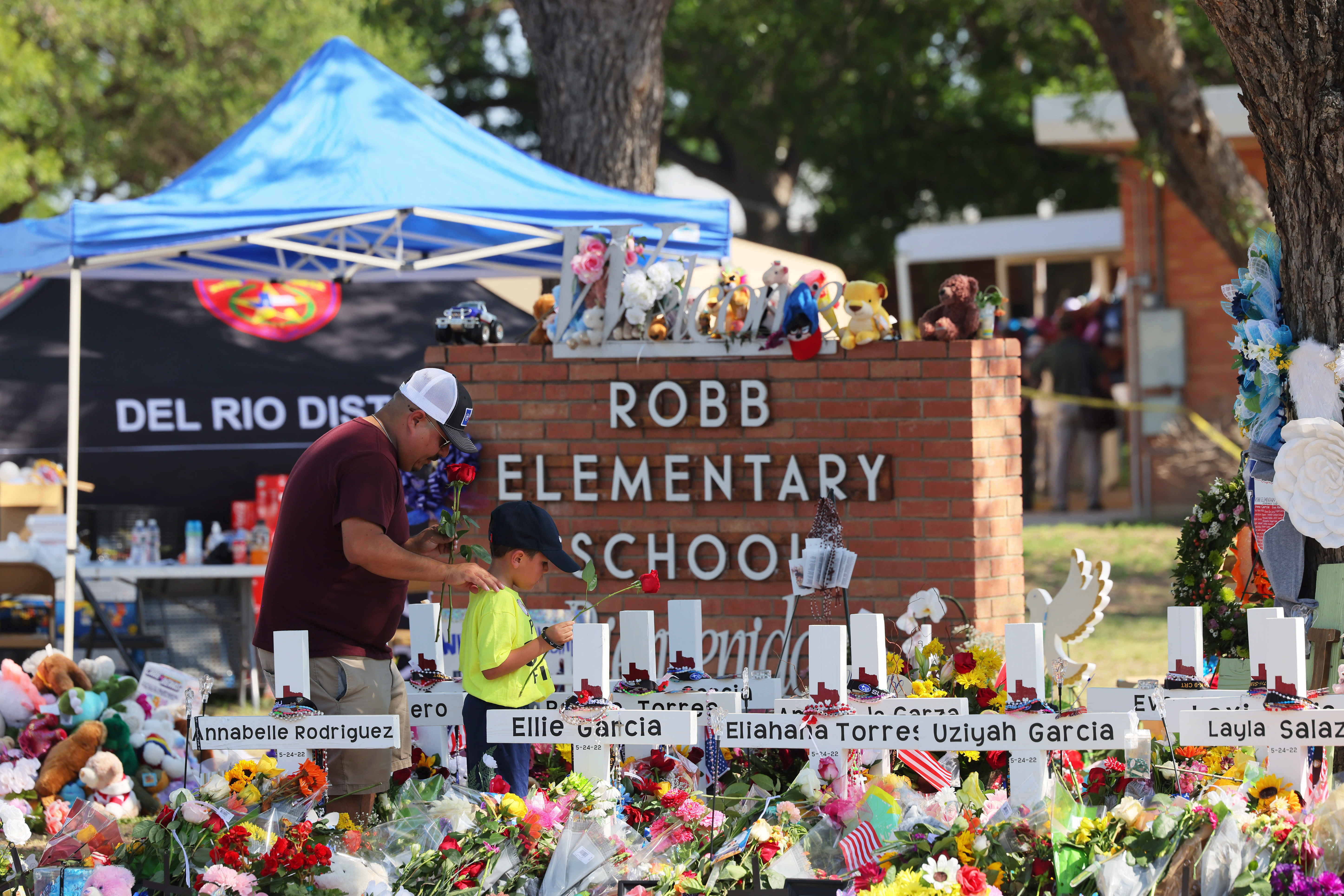 A man and a child pay their respects at a memorial to the victims of the Robb Elementary School mass shooting on Saturday in Uvalde, Texas. (Getty Images)