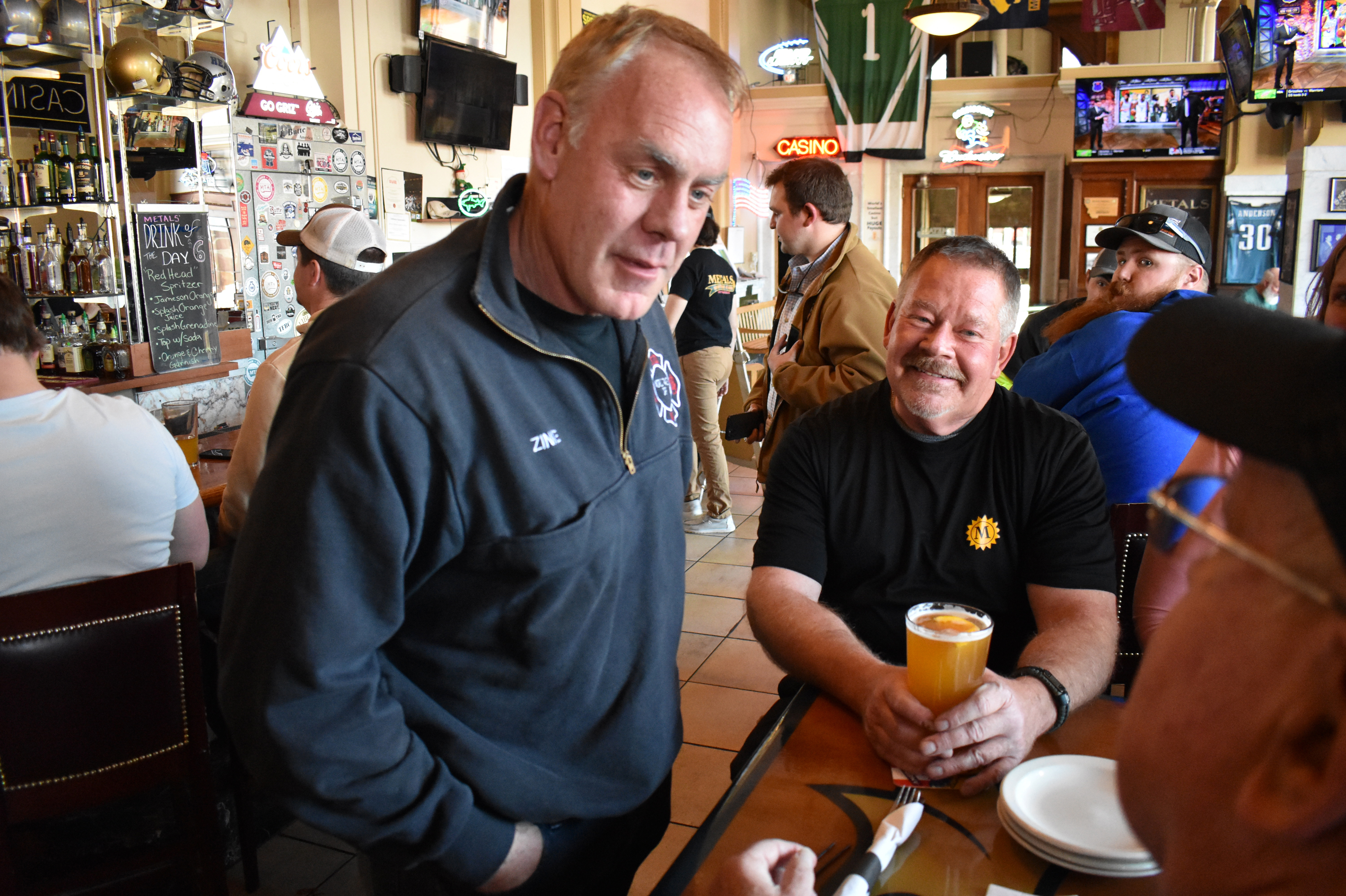 Former Interior Secretary Ryan Zinke, left, speaks with patrons at Metals Sports Bar and Grill on May 13 in Butte, Mont. Zinke is seeking election to a newly created U.S. House district.