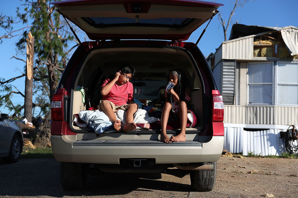 Carlos and Jessica Deviana sit in the back of their father's SUV, which they were using as a bedroom after Hurricane Michael destroyed their home in Panama City, Fla., in October 2018.