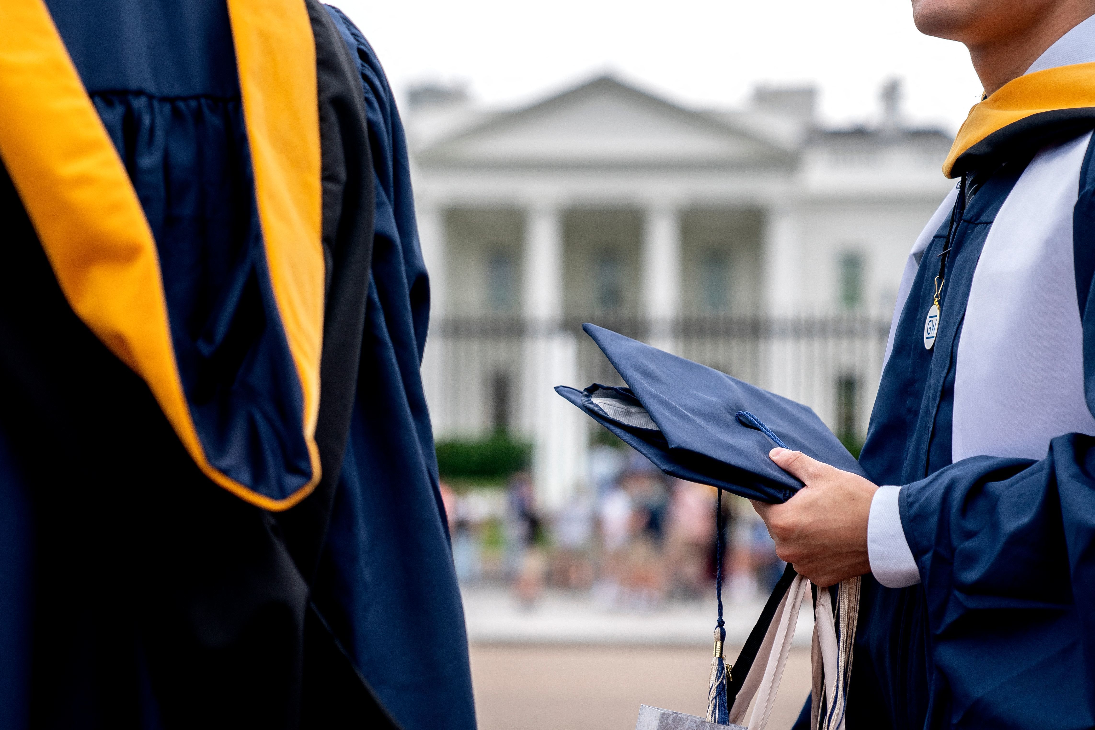 Students from George Washington University wear their graduation gowns outside the White House in May. (AFP via Getty Images)