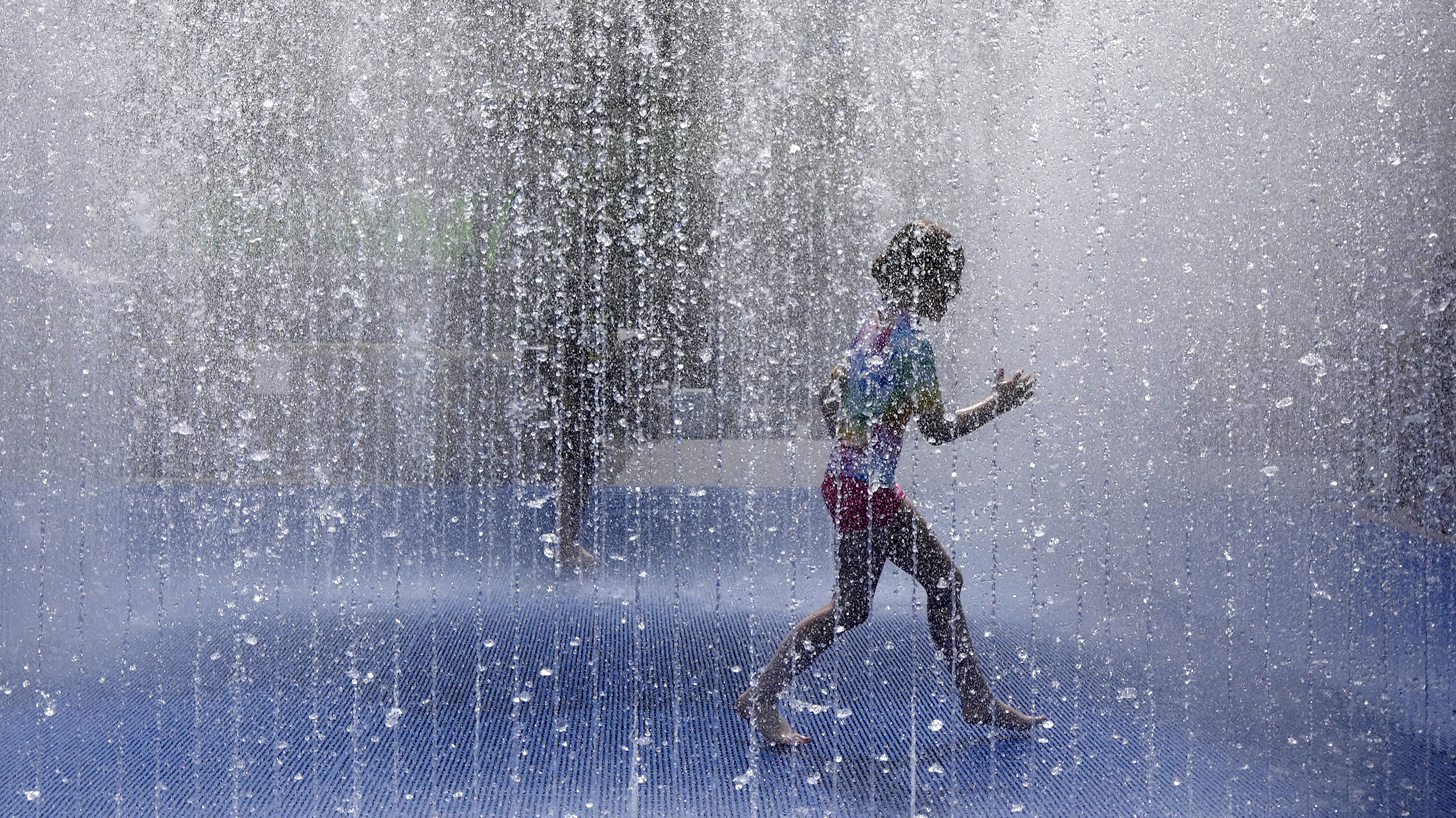 A child plays in a fountain in the warm weather in London, Friday, June 17, 2022. A blanket of hot air stretching from the Mediterranean to the North Sea is giving much of western Europe its first heat wave of the summer, with temperatures forecast to top 30 degrees Celsius (86 degrees Fahrenheit) from Malaga to London on Friday.