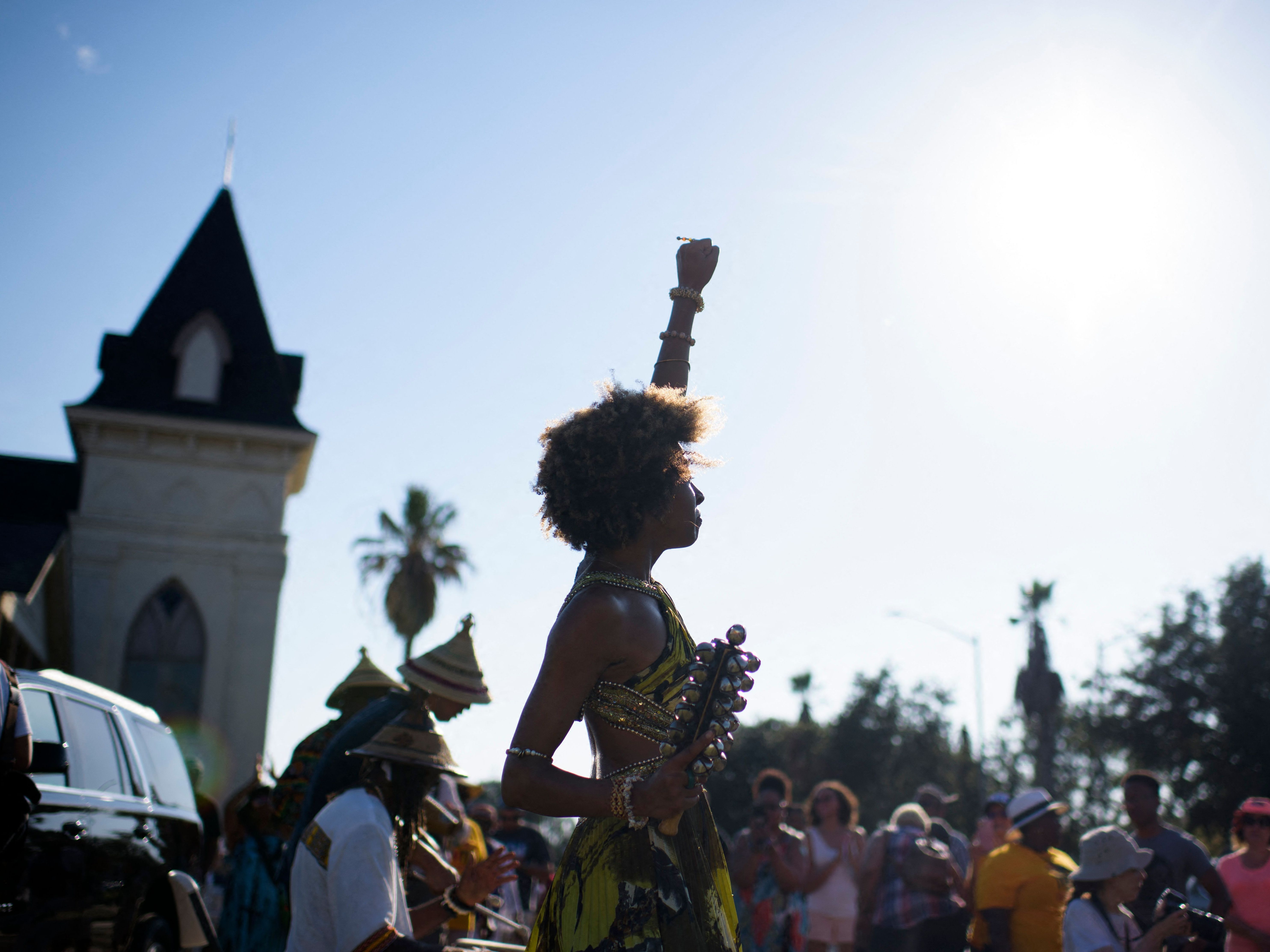 Prescylia Mae raises her fist in the air during a Juneteenth re-enactment celebration in Galveston, Texas, on June 19, 2021. (AFP via Getty Images)