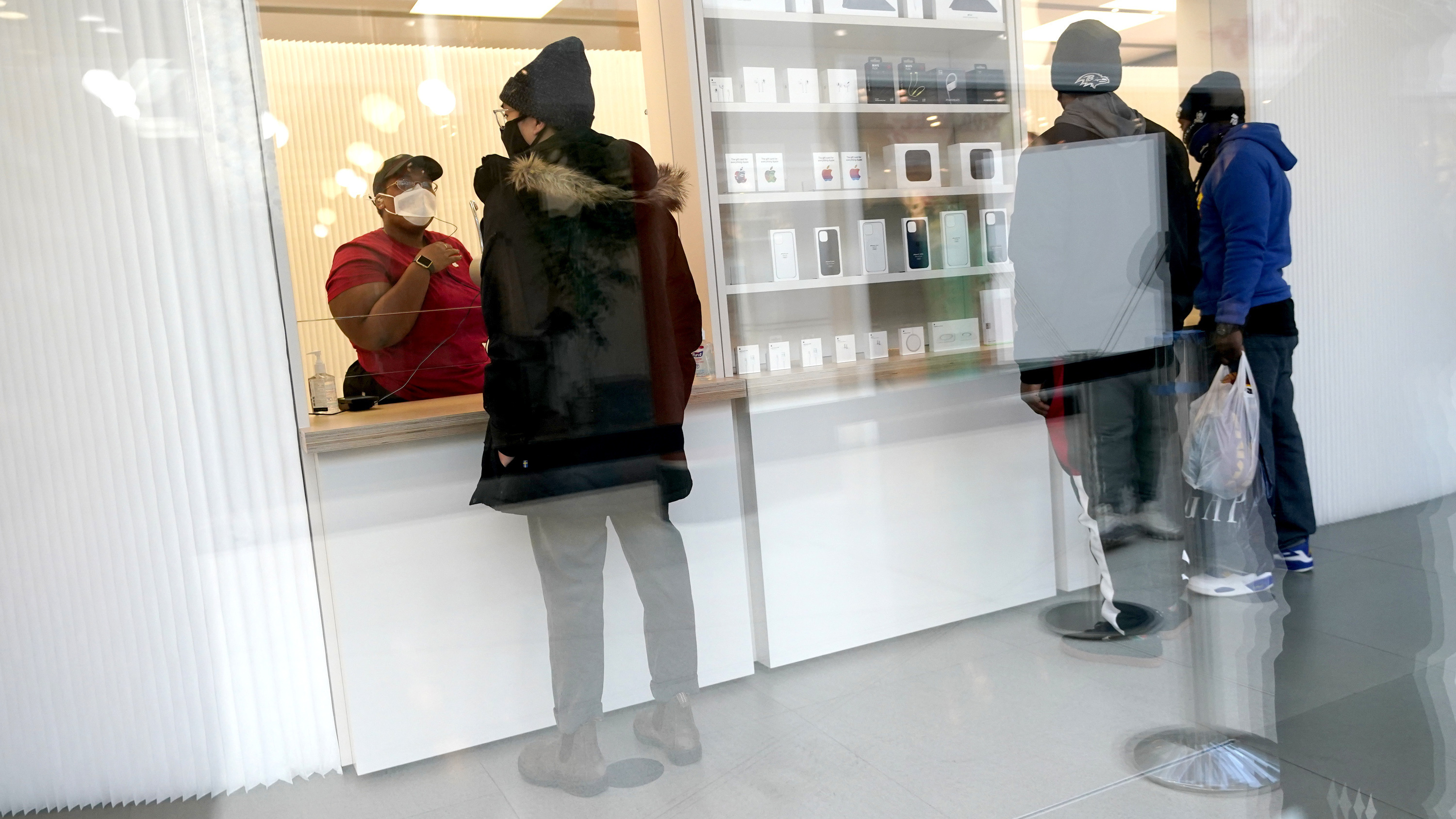 Customers pick up online orders at the Apple Store at the Towson Town Center in December 2020 in Towson, Md. Apple store employees in the Baltimore suburb voted to unionize by a nearly 2-to-1 margin on Saturday.