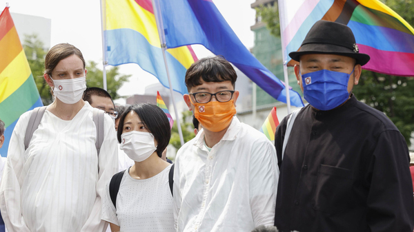 Plaintiffs speak to journalists after a court ruling in Osaka, western Japan Monday, June 20, 2022.