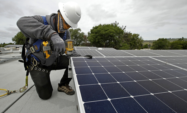 Gen Nashimoto, of Luminalt, installs solar panels in Hayward, Calif., on Wednesday, April 29, 2020.