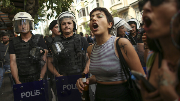 People shout slogans next to Turkish police officers during the LGBTQ Pride March in Istanbul, Turkey, Sunday, June 26, 2022.