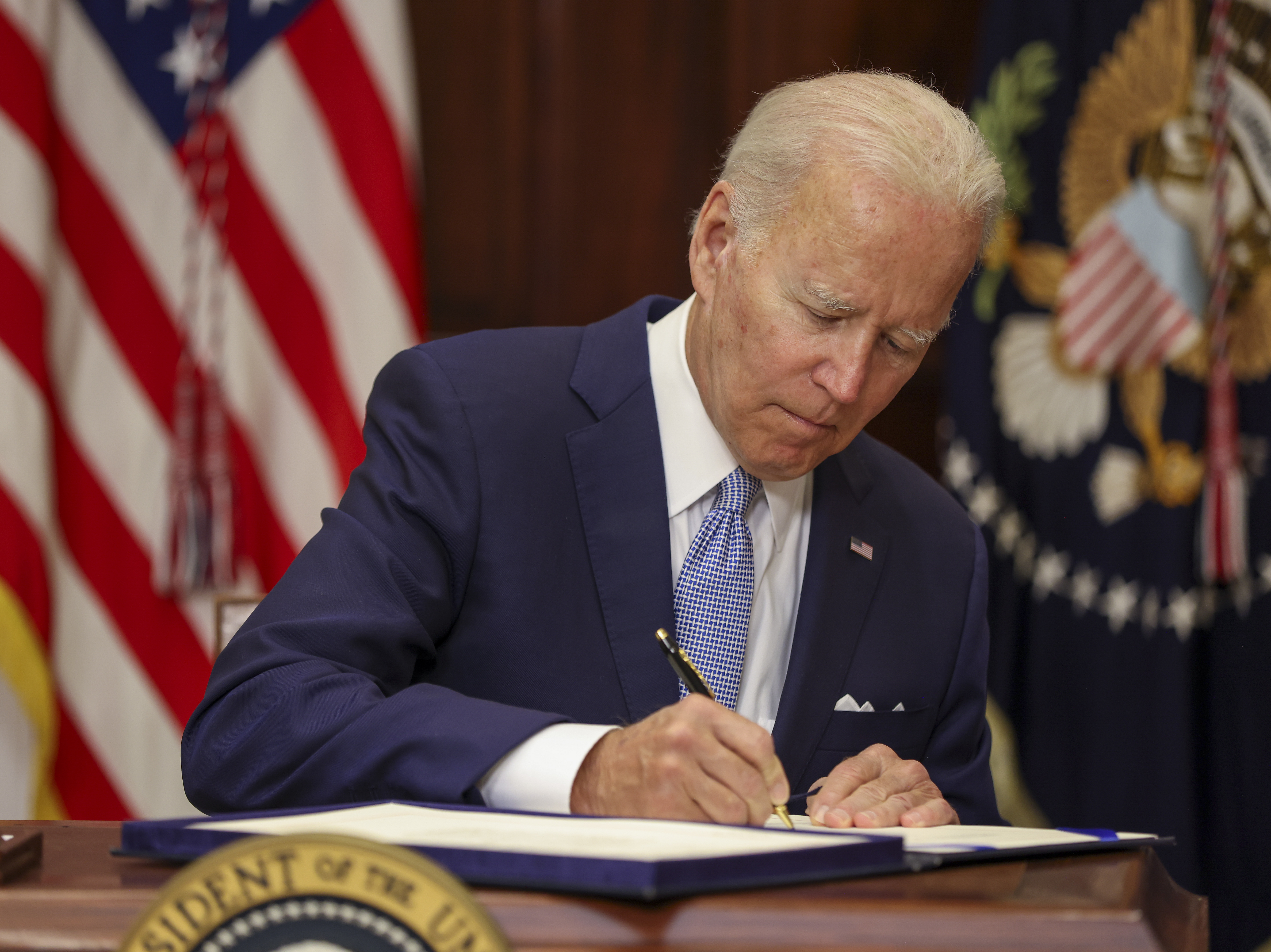 President Joe Biden signs the Bipartisan Safer Communities Act into law in the Roosevelt Room of the White House on Saturday. (Getty Images)