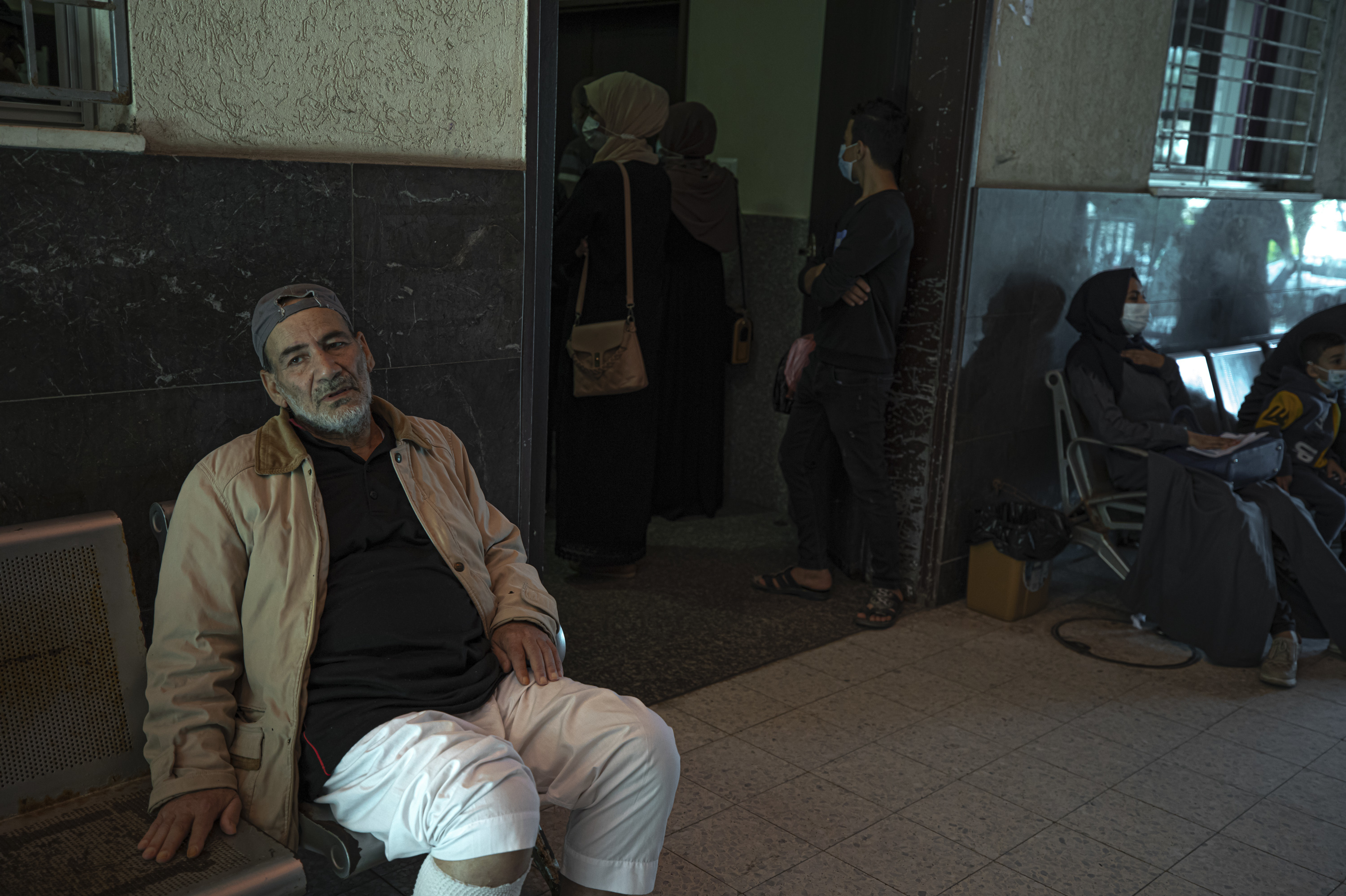 Yousef Al-Kurd, 70, a resident of Gaza with heart disease, waits to be seen by Dr. Saher Abu Ghali at Shifa Hospital. Al-Kurd is one of many Gazans who struggle to get permission to leave Gaza for medical treatment. (for NPR)