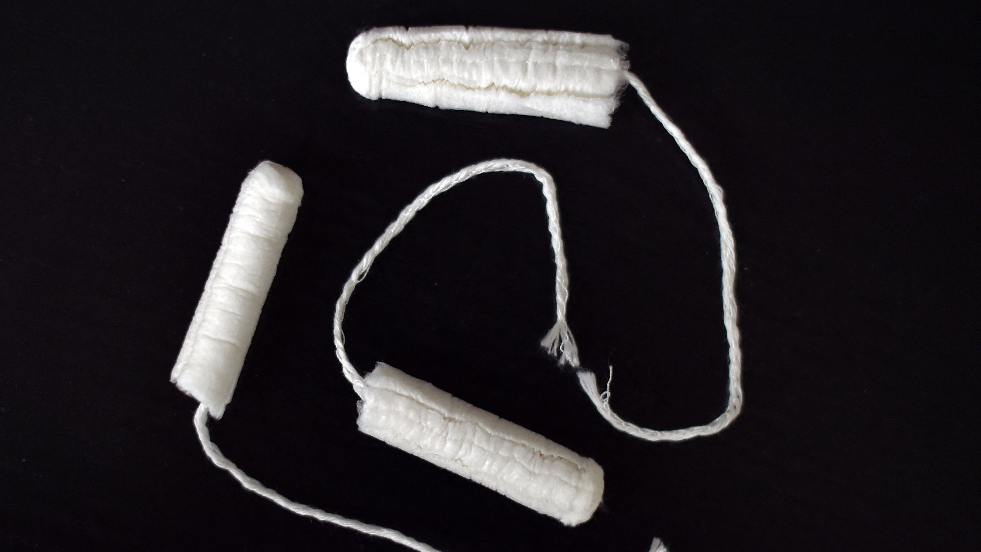 Three tampons on a black background.