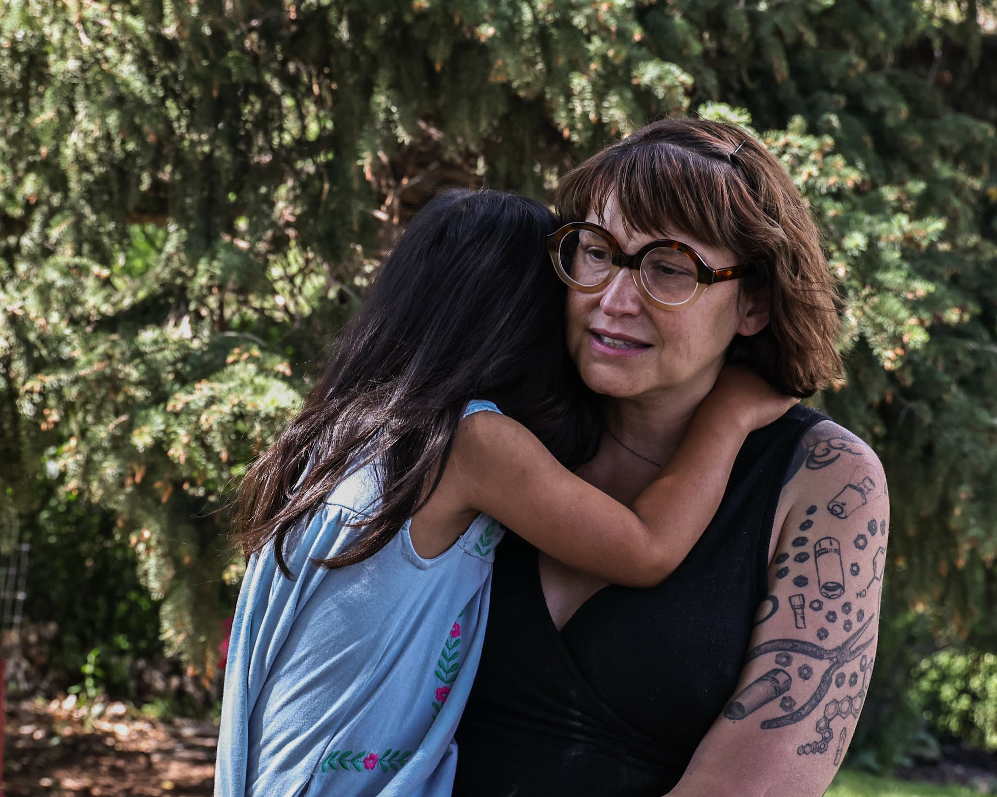 Jeni Rae Peters and daughter embrace at their home in Rapid City, S.D. In 2020, Peters was diagnosed with stage 2 breast cancer. After treatment, Peters estimates that her medical bills exceeded $30,000. (Dawnee LeBeau for NPR)