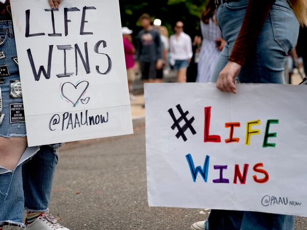 Abortion rights opponents hold signs outside the Supreme Court on June 27, 2022.