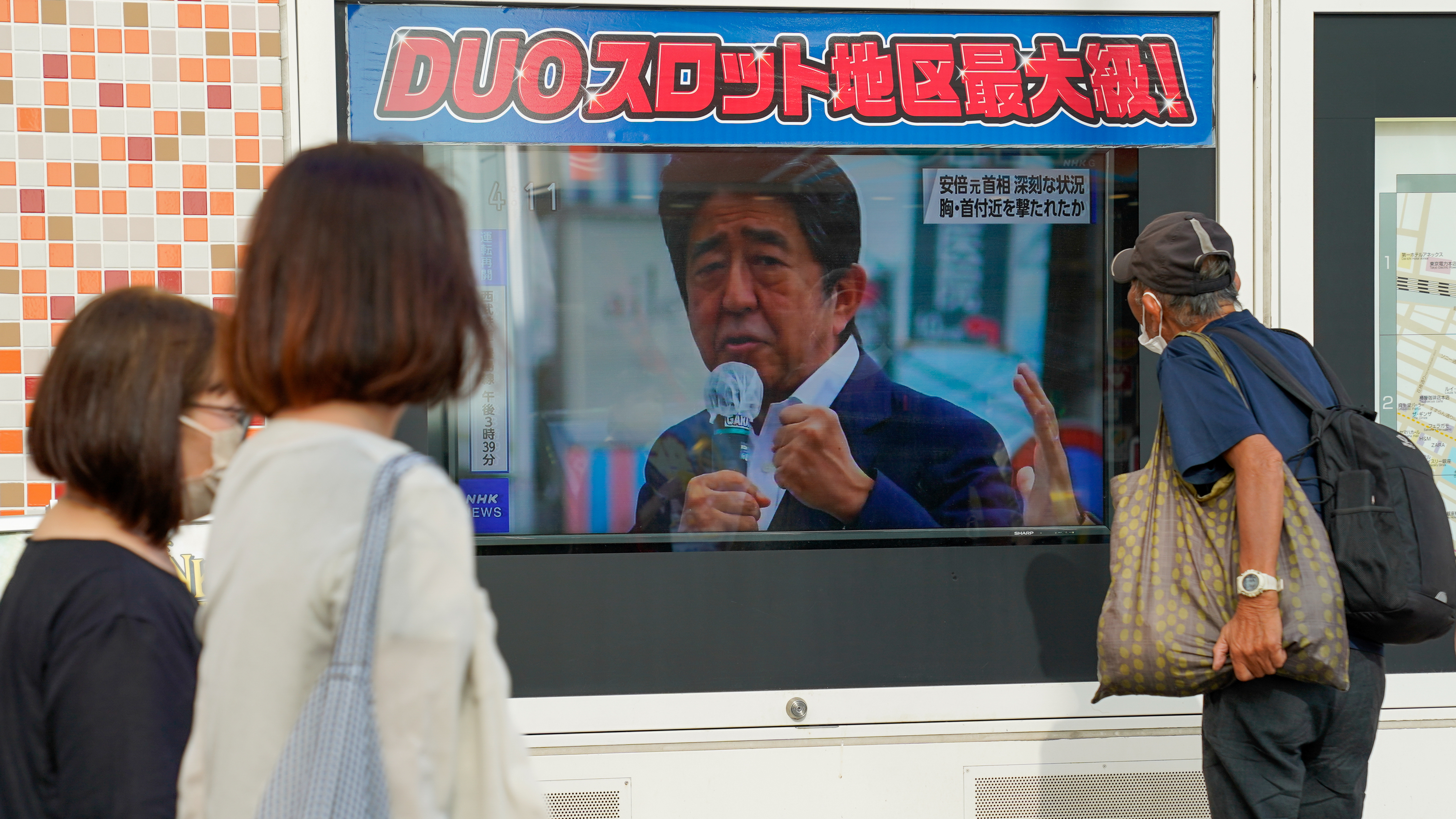 People in Tokyo watch TV news reporting Japan's former Prime Minister Shinzo Abe was shot on Friday. (Getty Images)