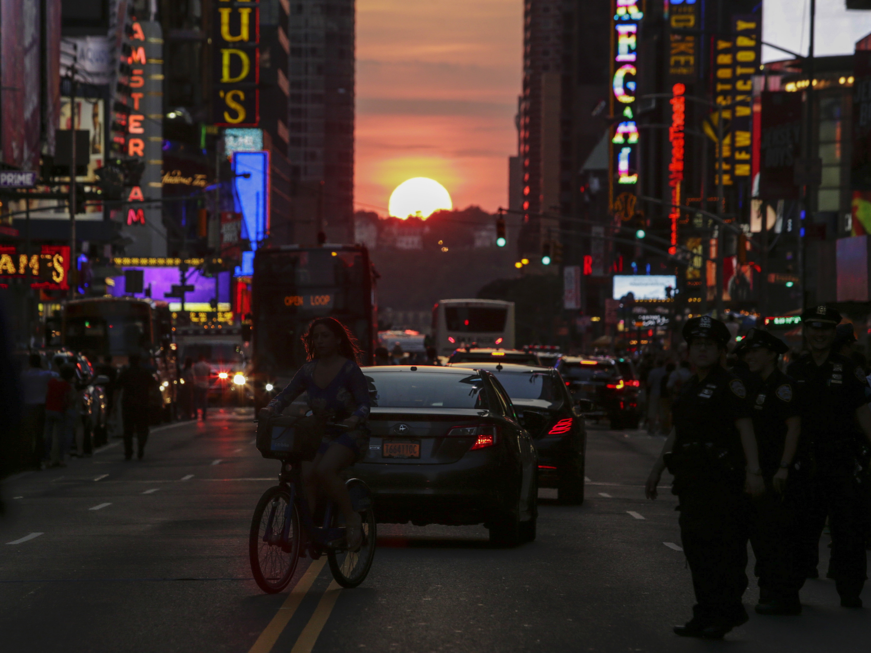 A woman rides a bike on 42nd St. in New York during Manhattanhenge in 2016. (AFP via Getty Images)