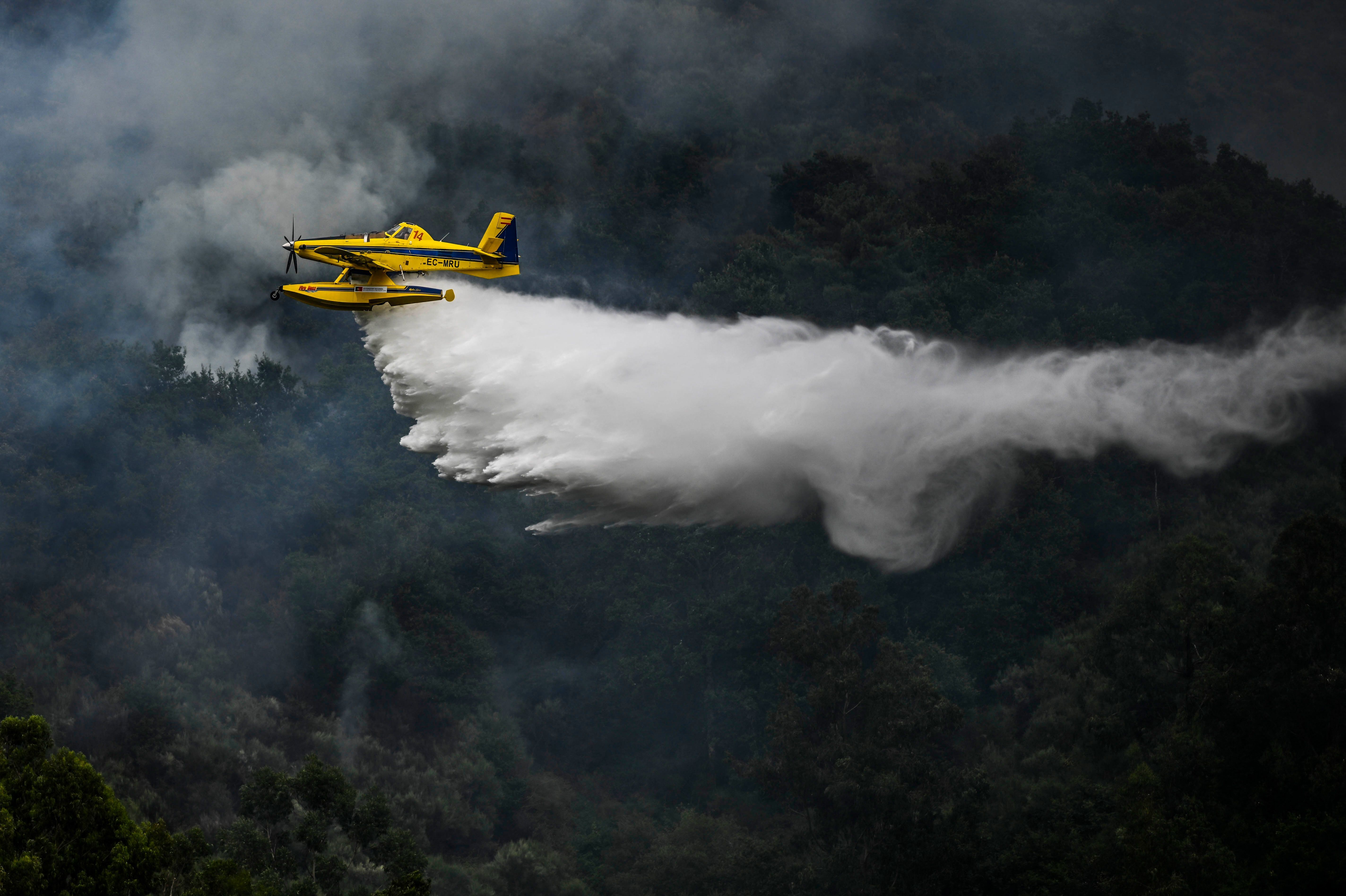 A firefighter aircraft drops water in a wildfire in Portugal on Saturday. (AFP via Getty Images)