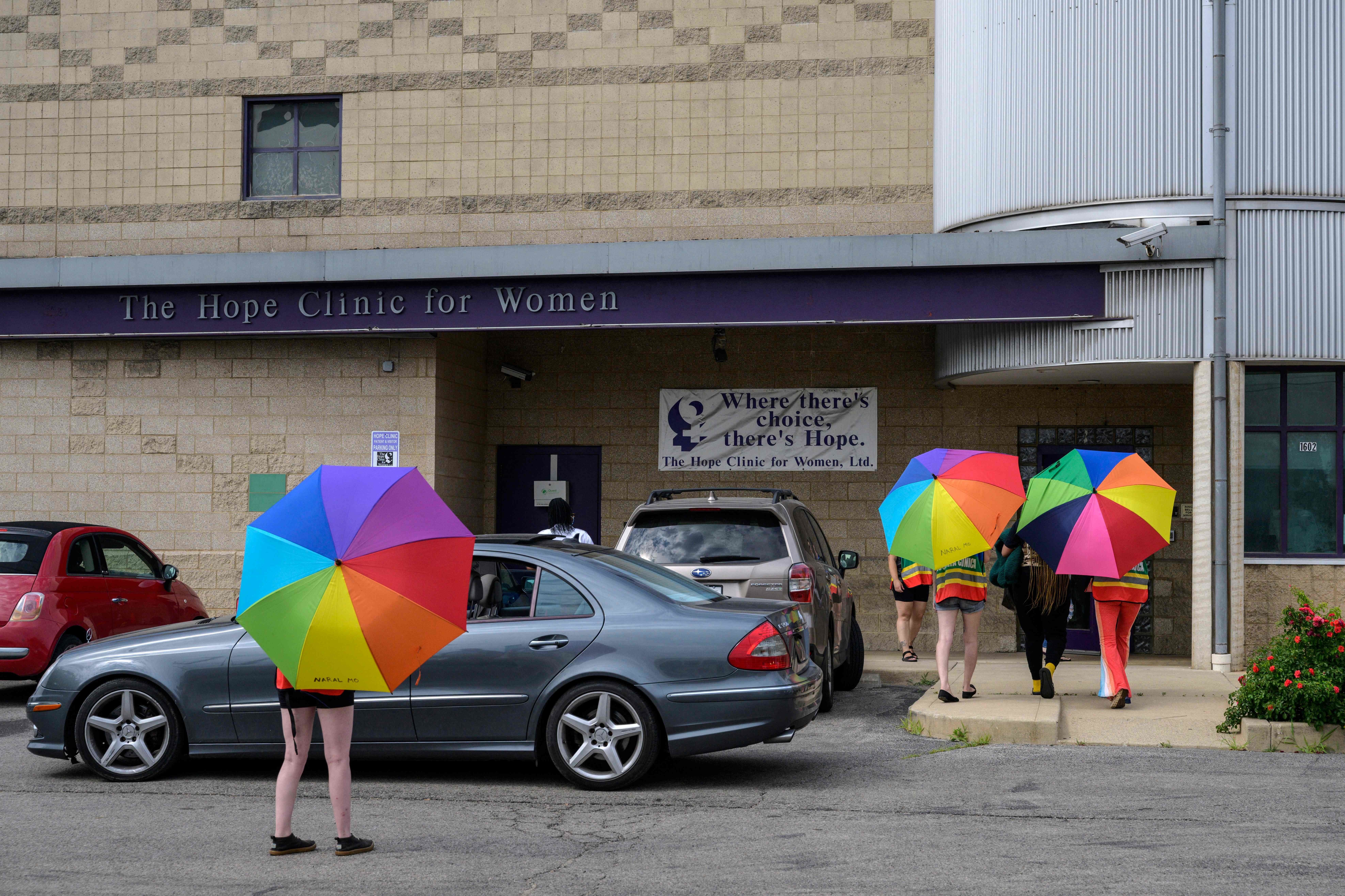 Volunteer clinic escorts shield a patient from anti-abortion activists outside the Hope Clinic for Women in Granite City, Illinois, last month. Clinics in states like Illinois, which has less restrictive laws, have been reporting an influx of patients from neighboring states. (AFP via Getty Images)