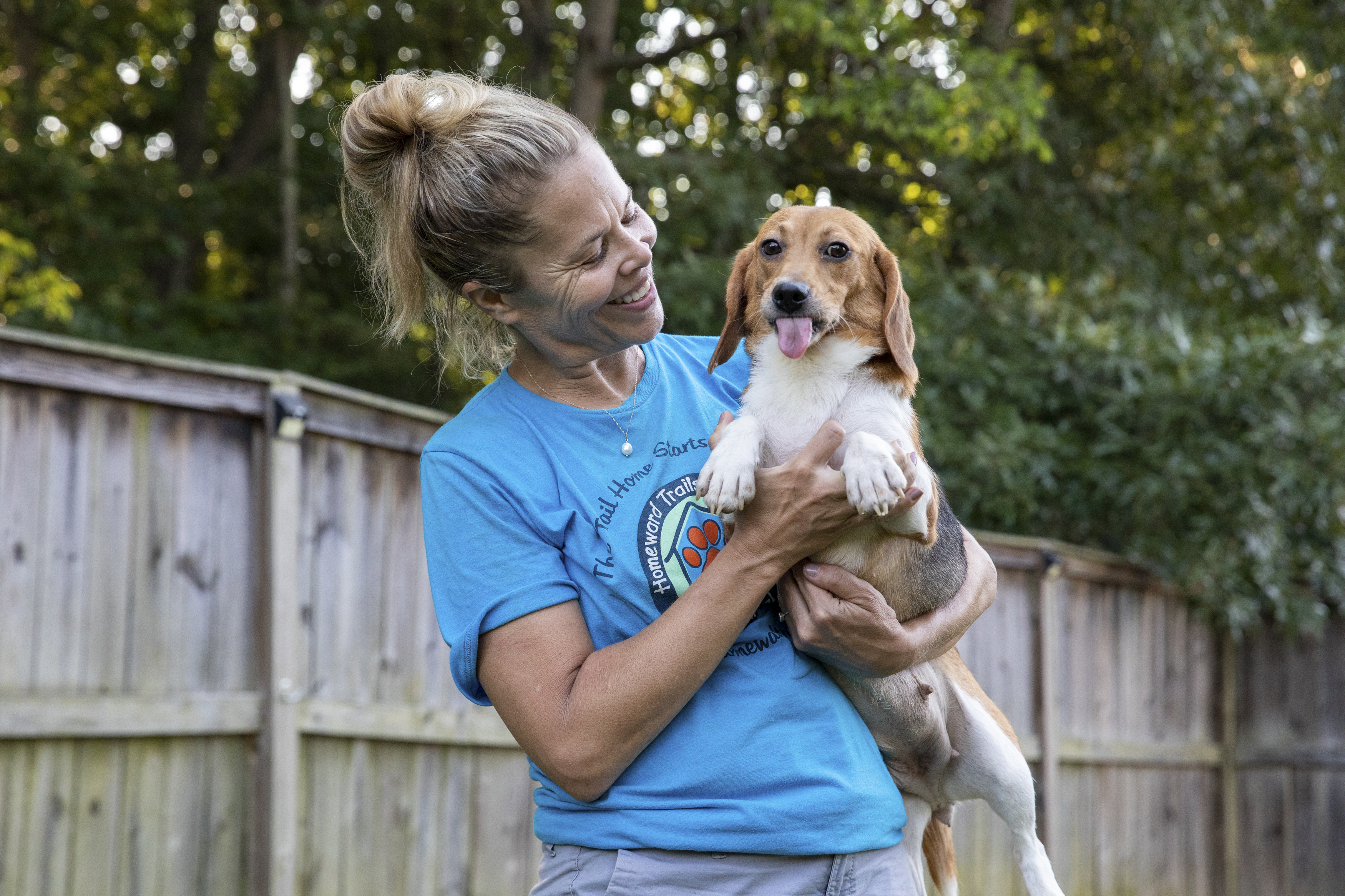 Sue Bell holds one of more than a dozen beagles that arrived at the headquarters of animal rescue group Homeward Trails in Fairfax Station, Va., on Thursday, while posing for a portrait. The dogs were a small portion of the roughly 4,000 beagles rescued from a research facility where the conditions were found to be inhumane. (Amanda Andrade-Rhoades for NPR)