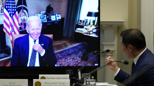 President Joe Biden, on screen at left, listens as SK Group Chairman Chey Tae-won, right, speaks from the Roosevelt Room of the White House on Tuesday.